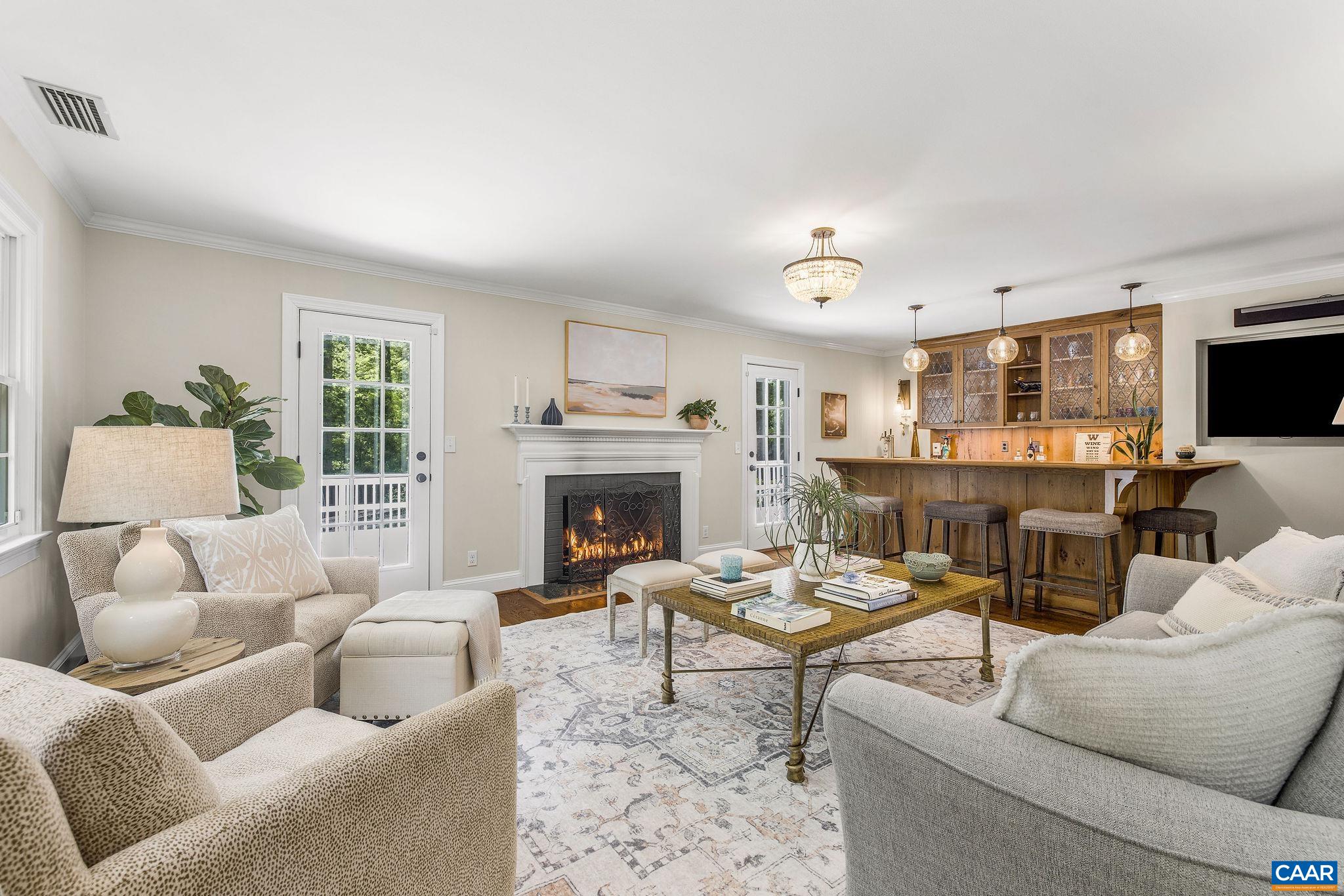 Living room with gas fireplace, easy access to the spacious deck, and a Karen Turner designed custom bar  is the perfect spot for gathering with family and friends.