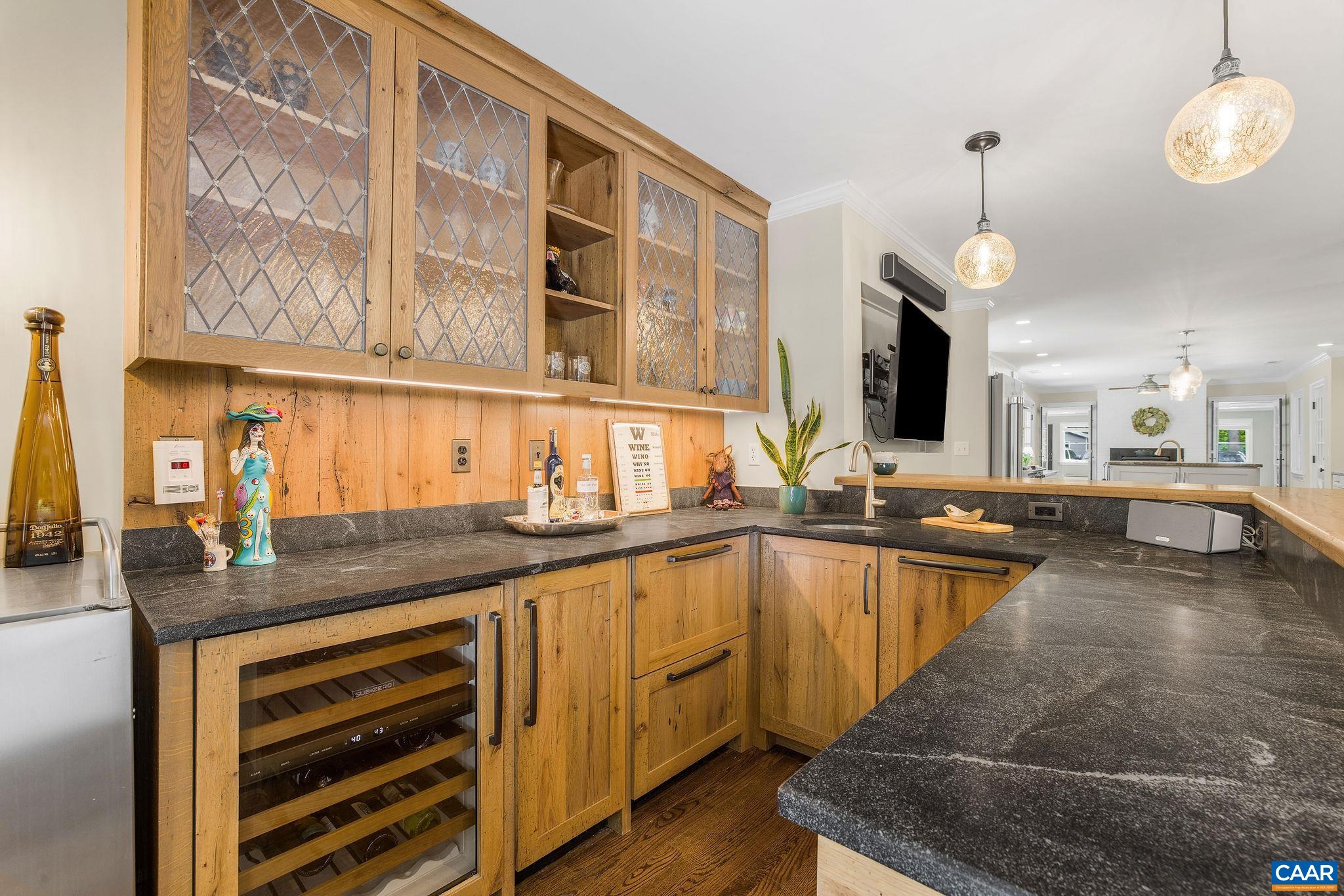 Incredible custom bar with wine fridge, kegerator, and custom cabinetry.