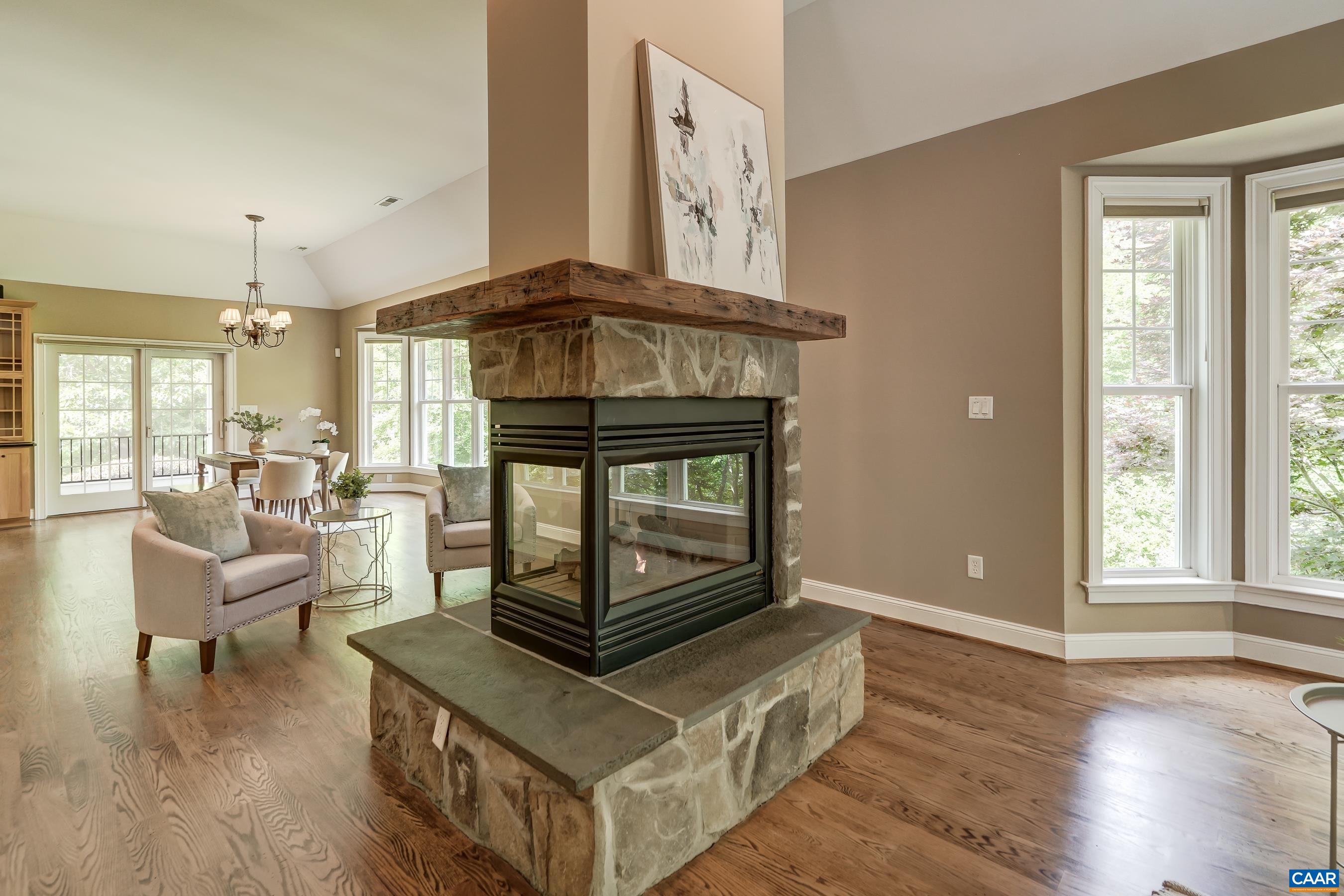 Three sided stone gas fireplace is the focal point of the room.
