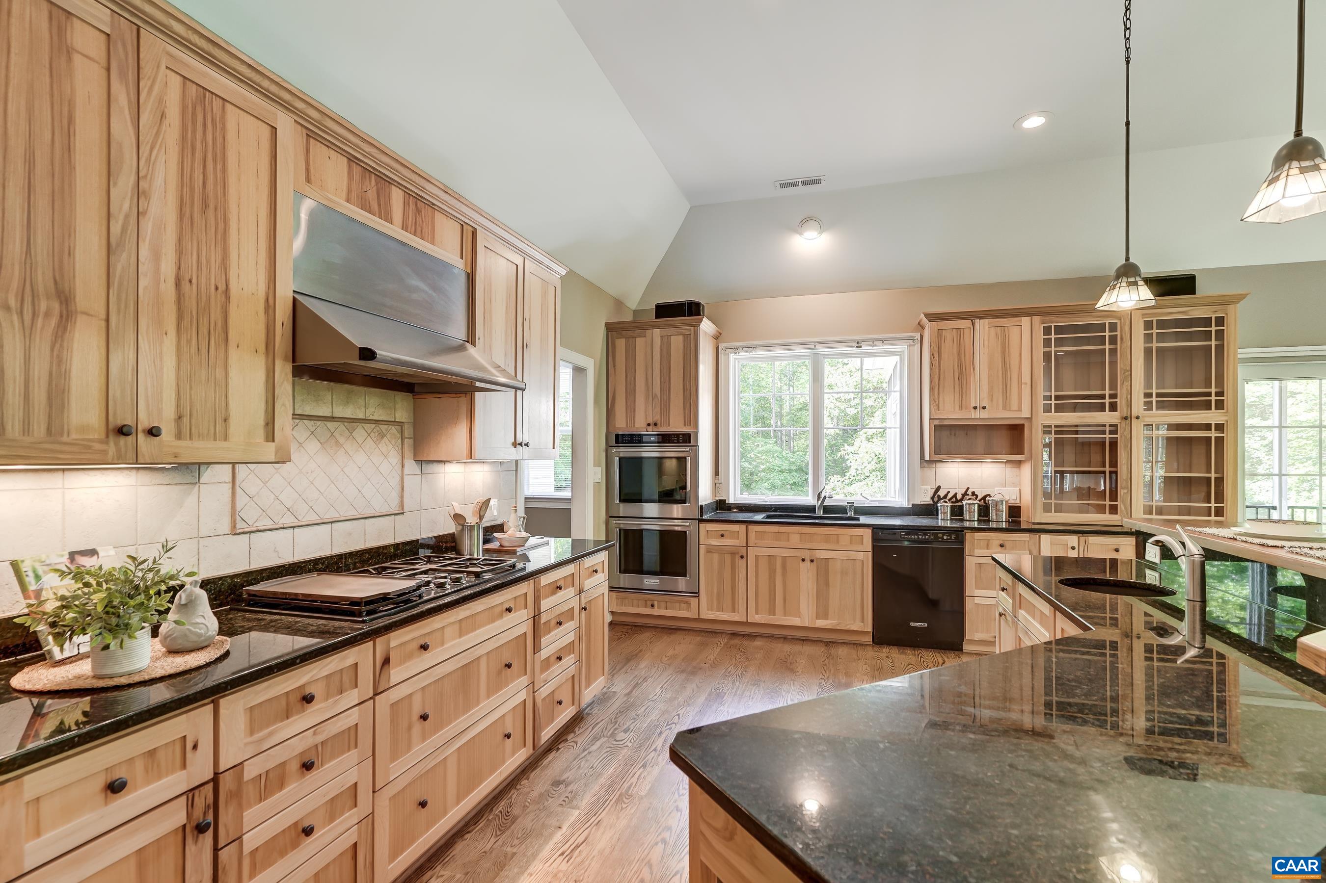 Gourmet kitchen features hickory wood cabinets, granite counters and a reclaimed cider barrel bar.