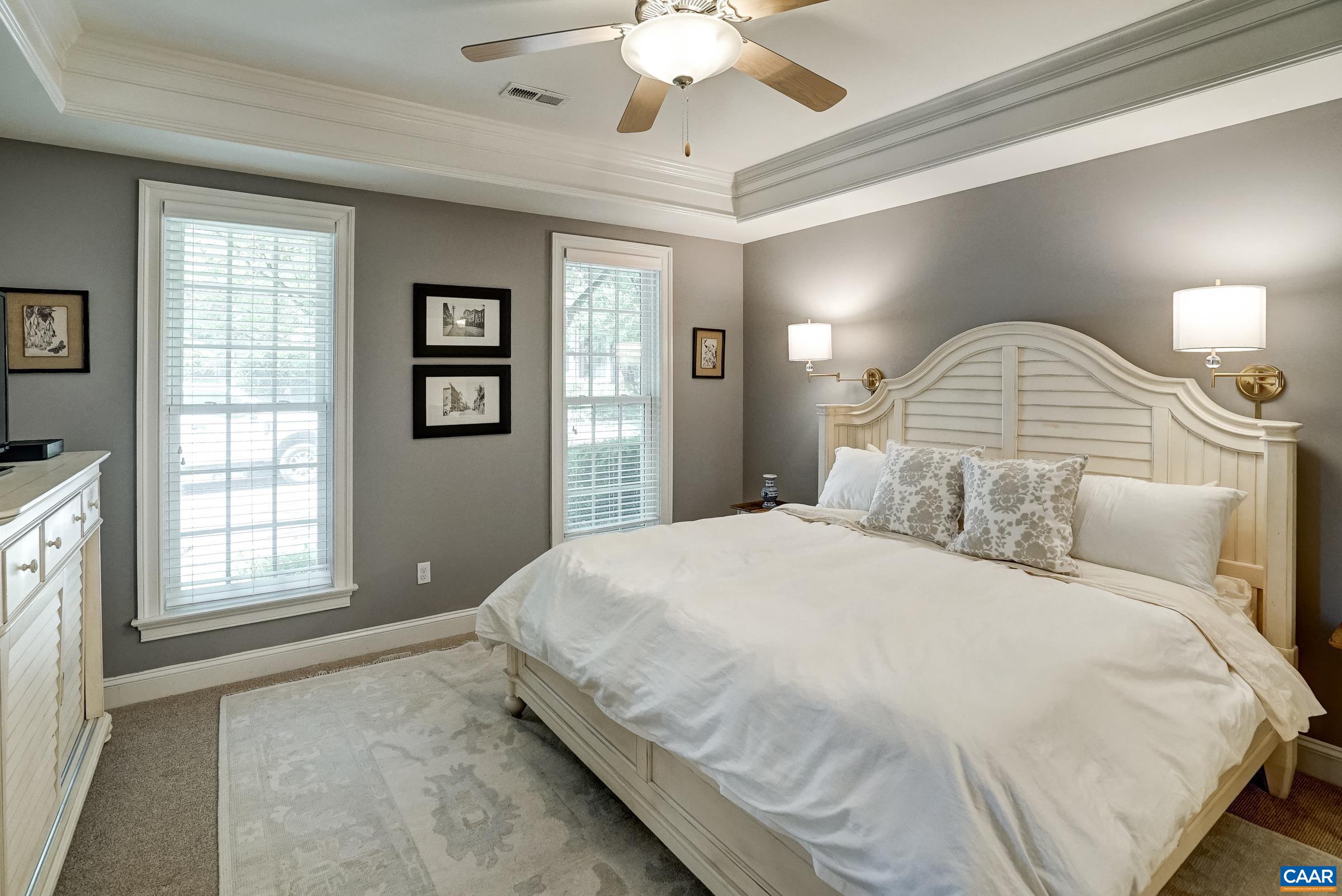 Main level primary suite features tray ceiling and fan. Main level primary suite features tray ceiling and fan.