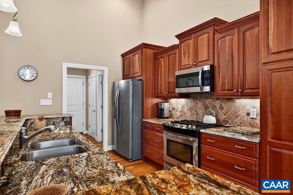 The spacious kitchen features cherry cabinetry, granite countertops, stainless steel appliances, and a gas range. The spacious kitchen features cherry cabinetry, granite countertops, stainless steel appliances, and a gas range.