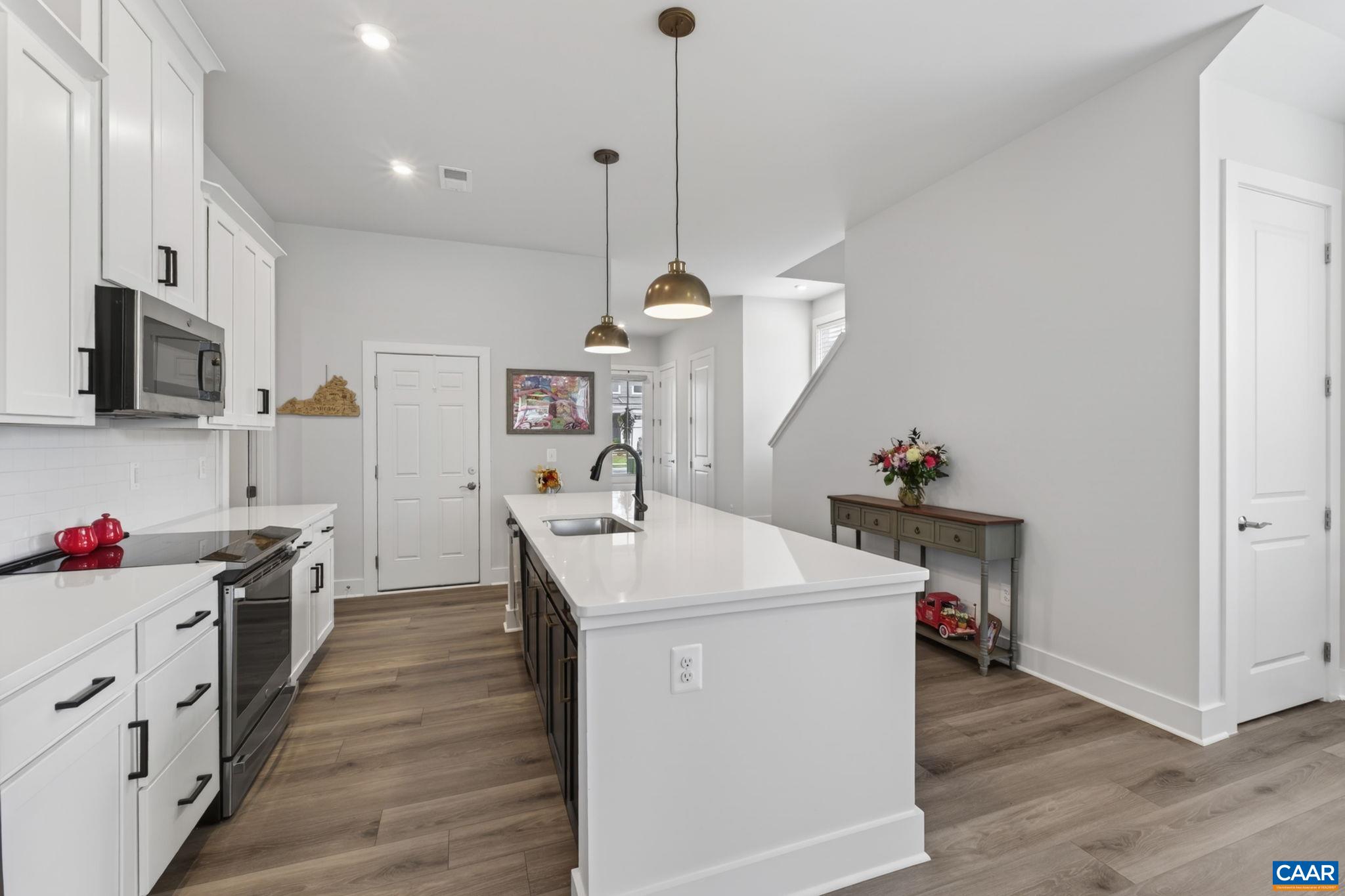 Kitchen has loads of cabinetry, and pantry door at right. Kitchen has loads of cabinetry, and pantry door at right.