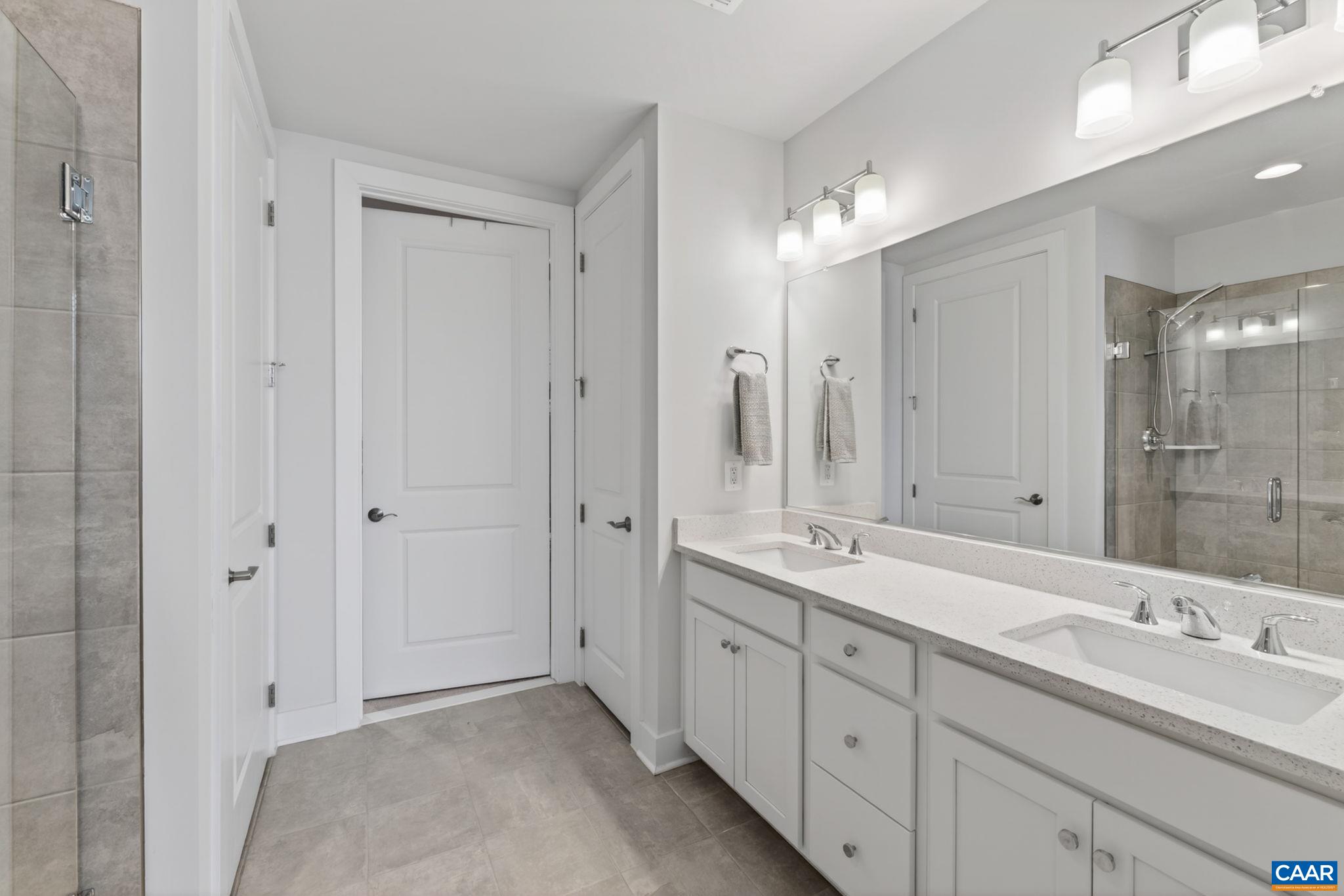 Primary bath with double sink quartz vanity with large walk-in closet. Primary bath with double sink quartz vanity with large walk-in closet.