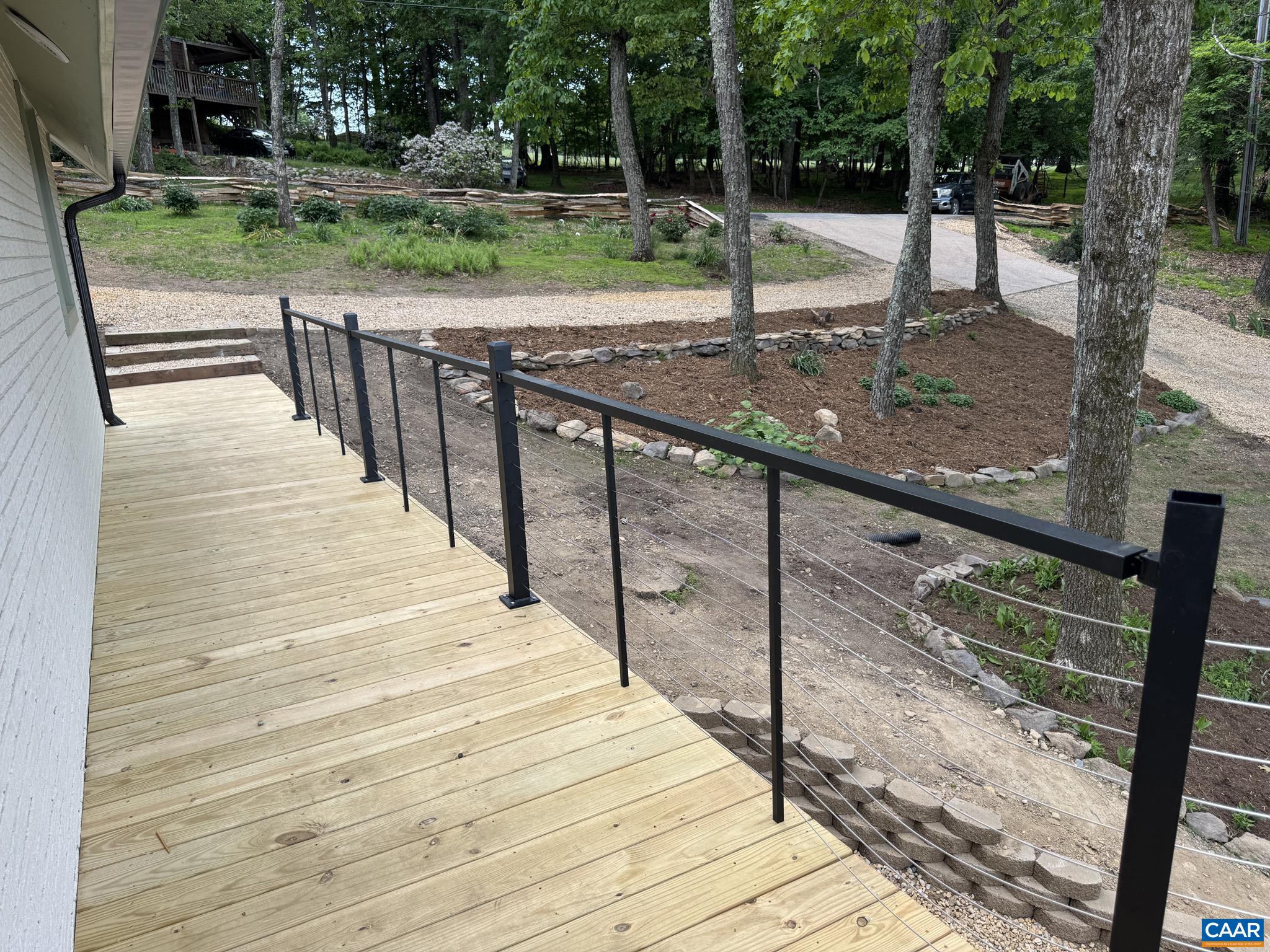 Modern Cable Deck Railing, and Yard Landscaped with Native Stone and a Split Rail Fence forged from Native Trees Modern Cable Deck Railing, and Yard Landscaped with Native Stone and a Split Rail Fence forged from Native Trees