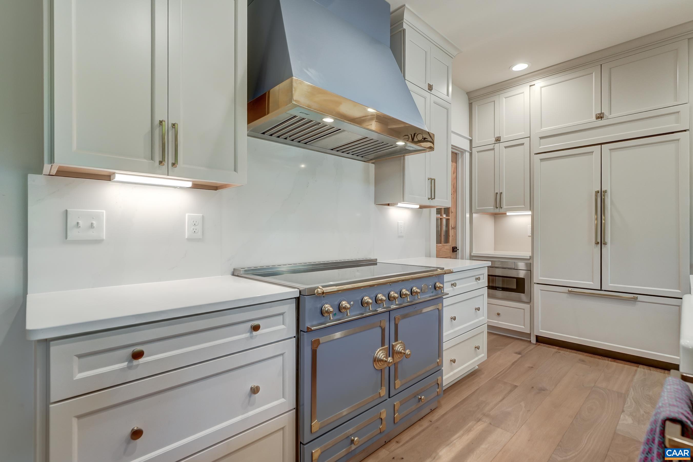High end appliances including La Cournue induction range and hood and Sub Zero paneled refrigerator. High end appliances including La Cournue induction range and hood and Sub Zero paneled refrigerator.