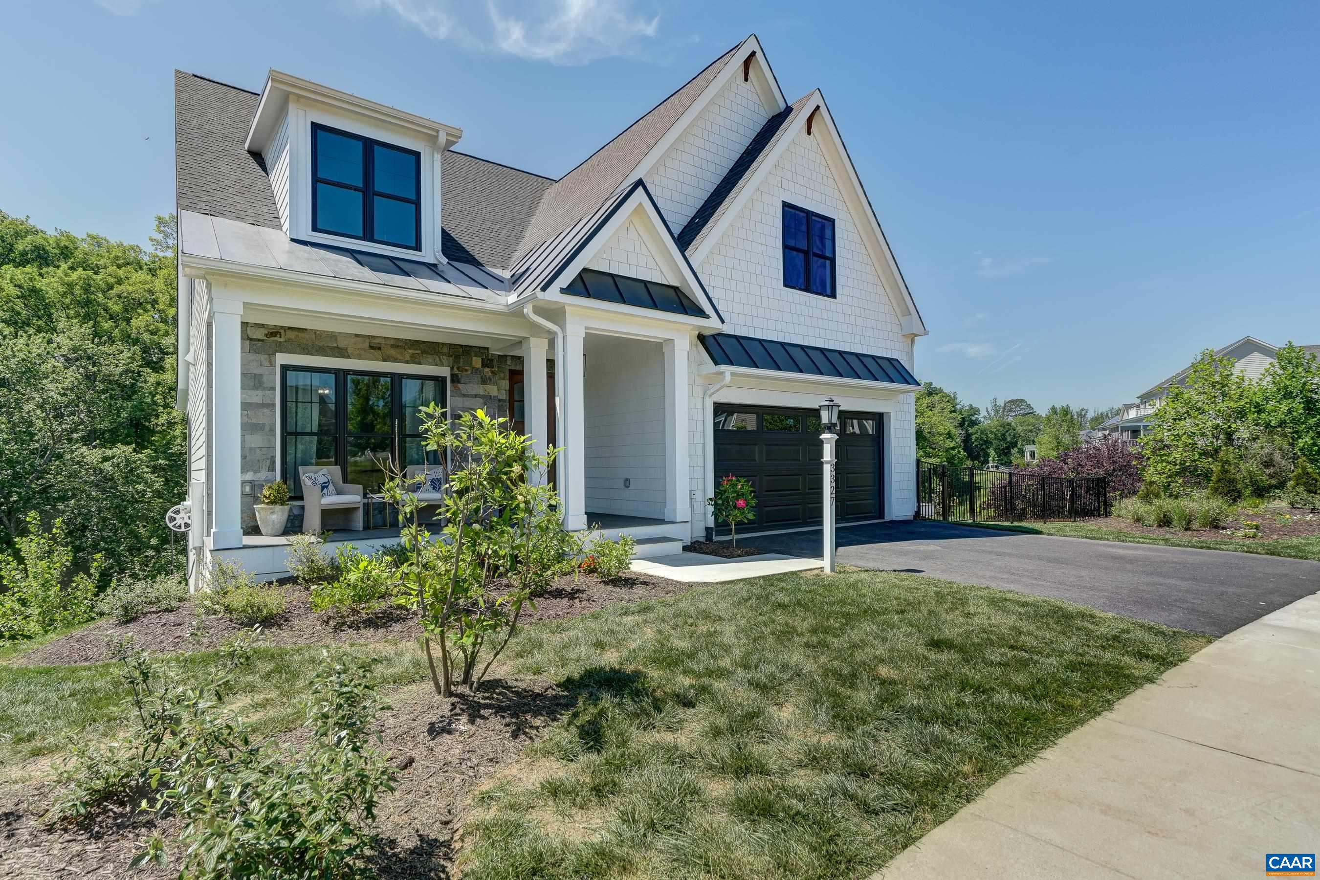 Farmhouse charm with low maintenance hardie plank siding, black window frames and carriage style garage door. Farmhouse charm with low maintenance hardie plank siding, black window frames and carriage style garage door.