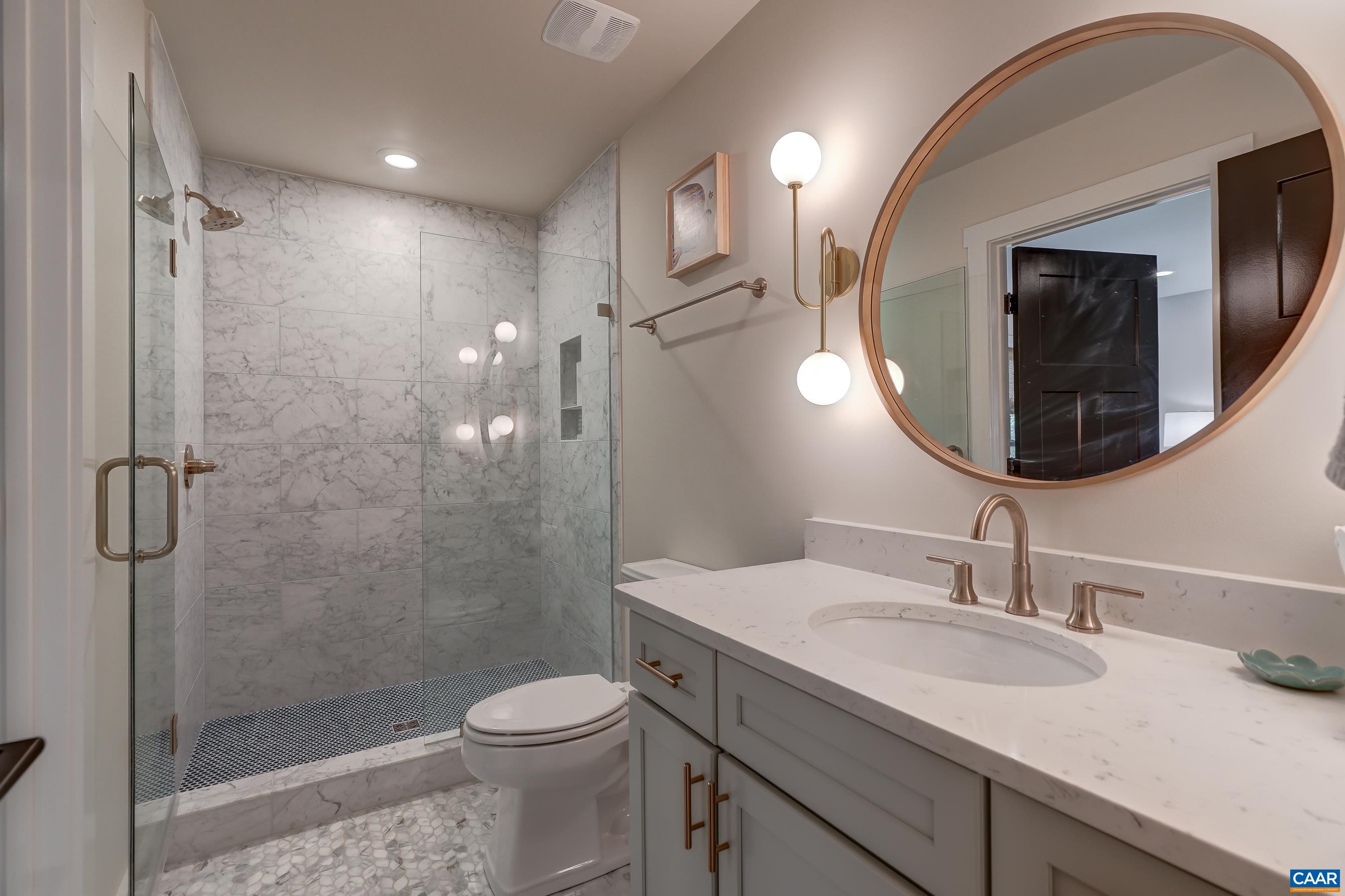Full hall bathroom with frameless glass shower. Full hall bathroom with frameless glass shower.