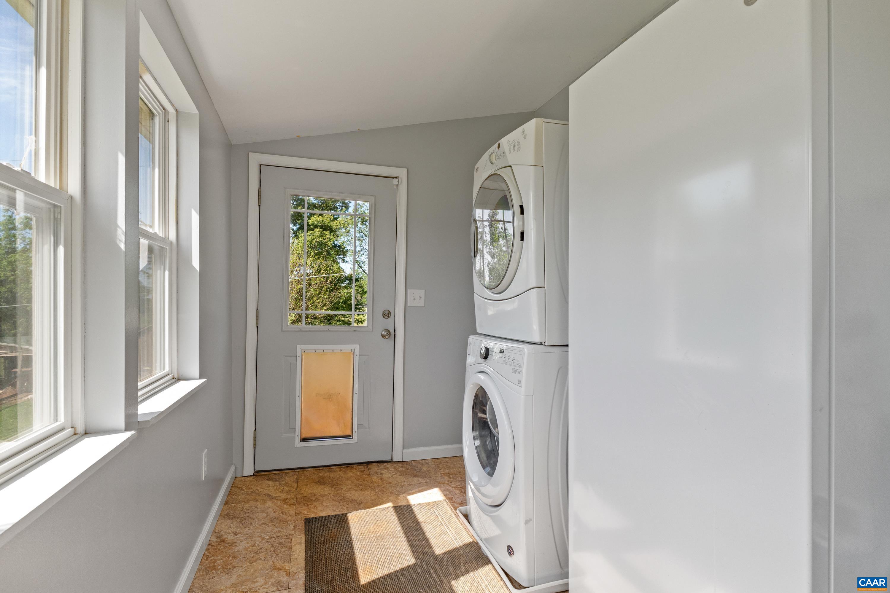Laundry space with exterior access, natural light, and room for household storage. Laundry space with exterior access, natural light, and room for household storage.