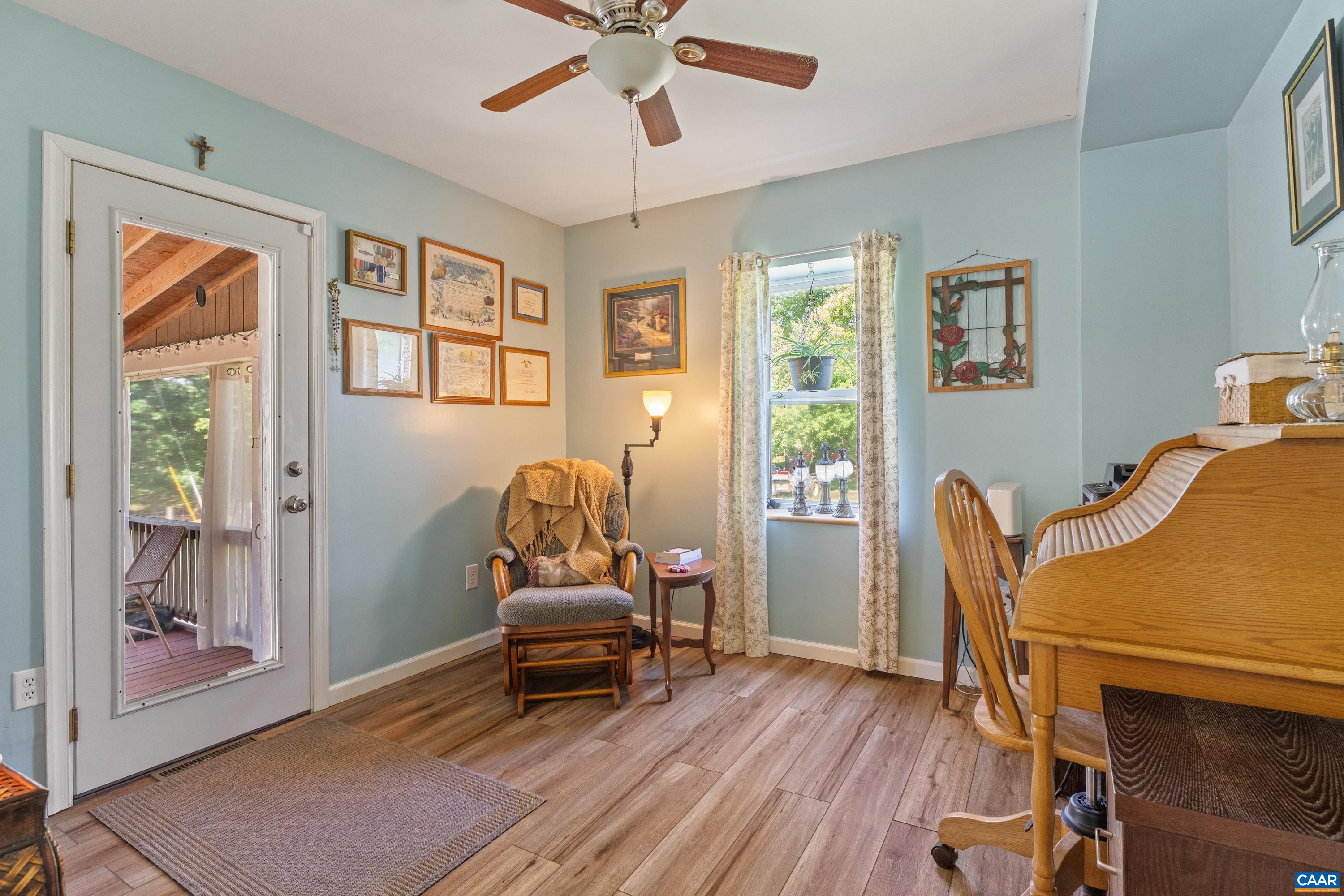 Main-level bedroom or flex room with ceiling fan, and natural light and exit to screened in porch. Main-level bedroom or flex room with ceiling fan, and natural light and exit to screened in porch.