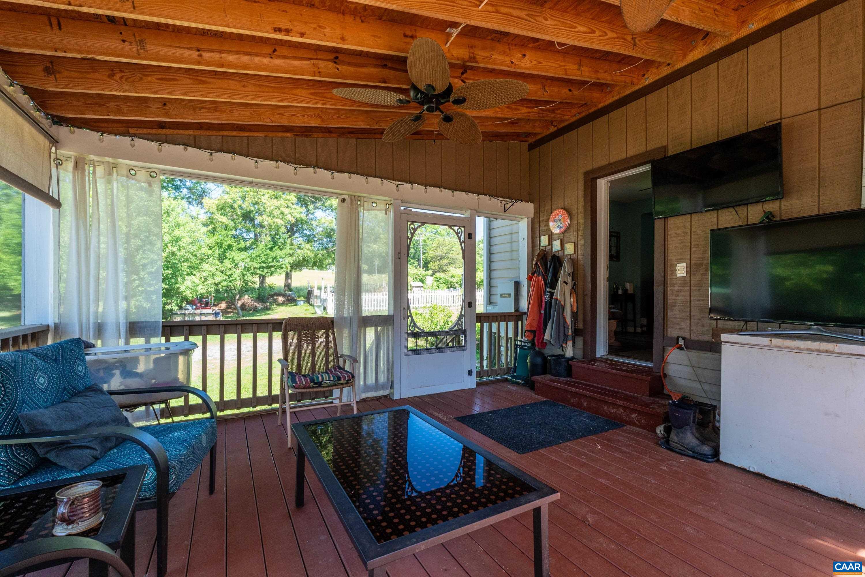 Screened three-season porch overlooking the property, ideal for relaxing, dining, or gathering. Screened three-season porch overlooking the property, ideal for relaxing, dining, or gathering.