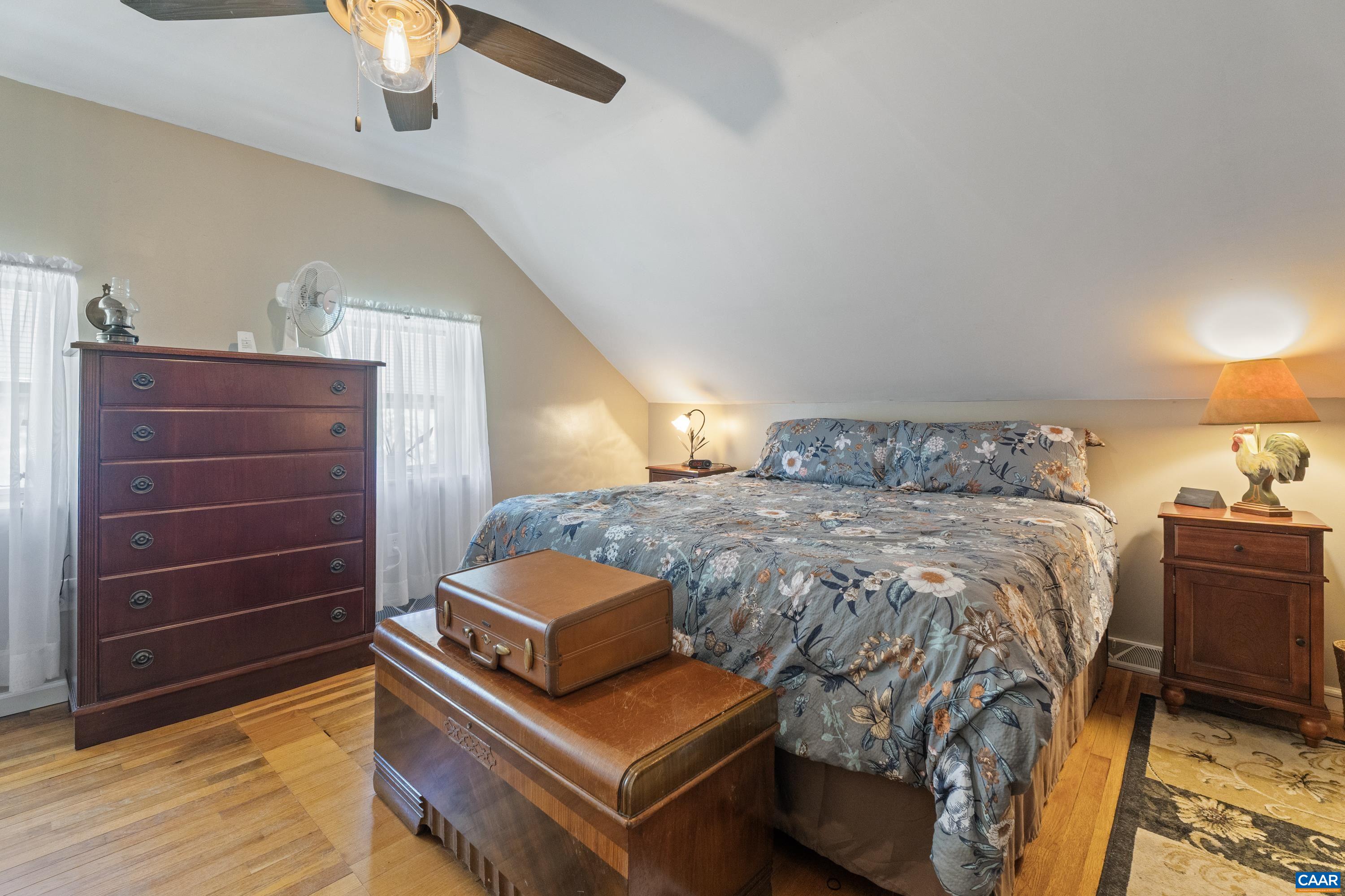 Bedroom with vaulted ceiling, wood accents, ceiling fan, comfortable natural light, and plenty of closet storage. Bedroom with vaulted ceiling, wood accents, ceiling fan, comfortable natural light, and plenty of closet storage.