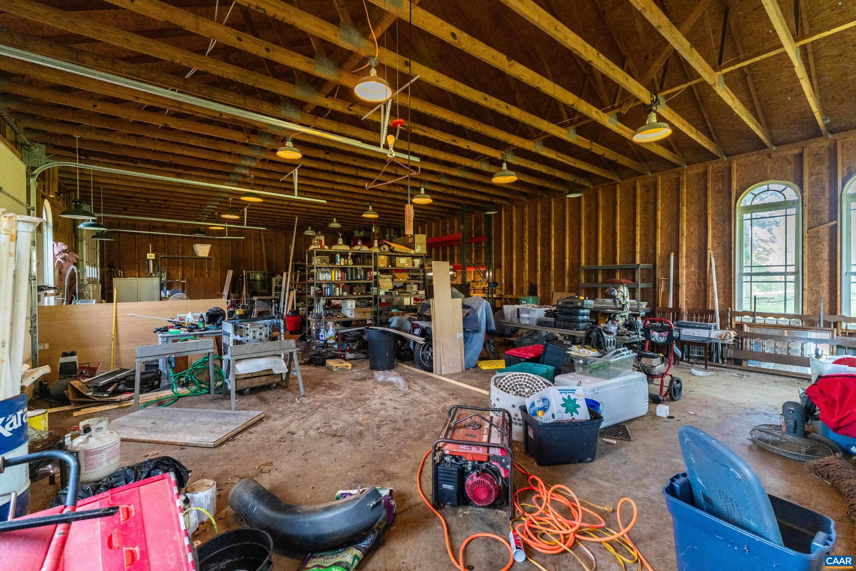 Interior of the detached workshop offering substantial open workspace, storage, and utility potential. Interior of the detached workshop offering substantial open workspace, storage, and utility potential.