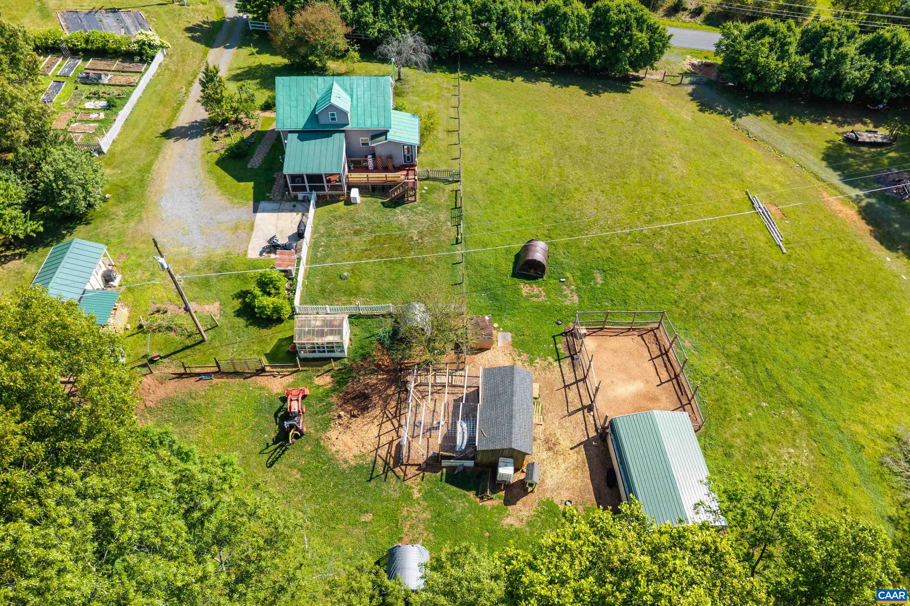 Aerial overview of the property’s gardens, outbuildings, home, and open acreage. Aerial overview of the property’s gardens, outbuildings, home, and open acreage.