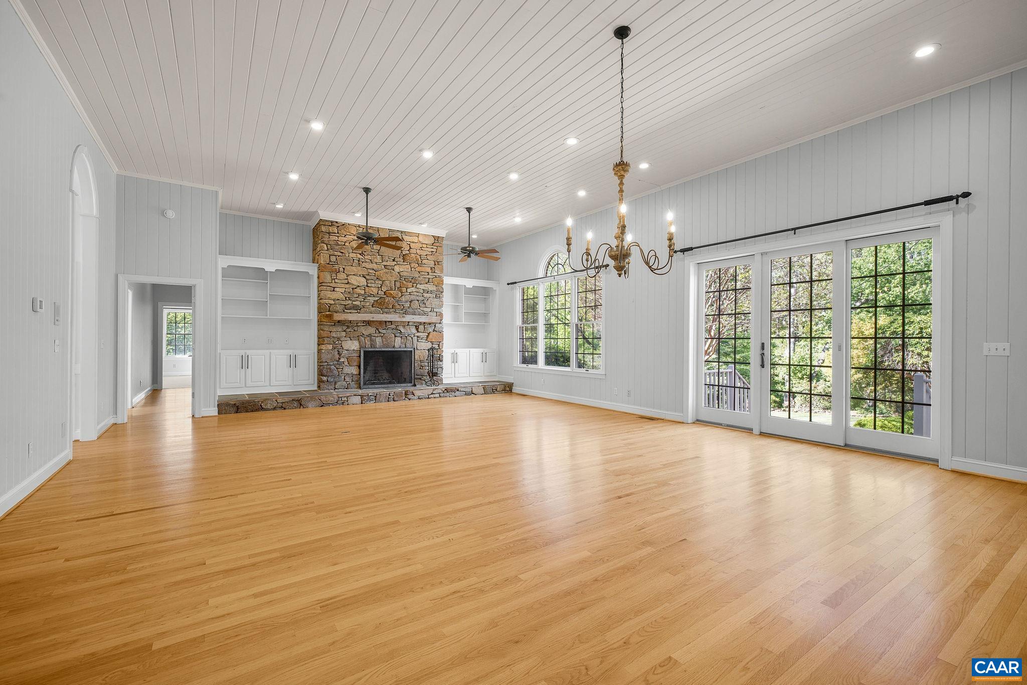 Great room with soaring ceiling, hardwood, and stunning stone fireplace. Current owners used this room as both the dining and living room, as it's located just off the kitchen. Great room with soaring ceiling, hardwood, and stunning stone fireplace. Current owners used this room as both the dining and living room, as it's located just off the kitchen.