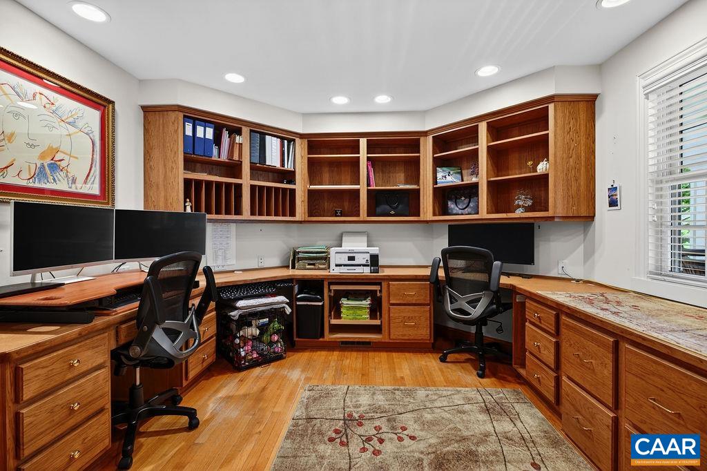 A spacious office with custom built-in cabinetry and shelving