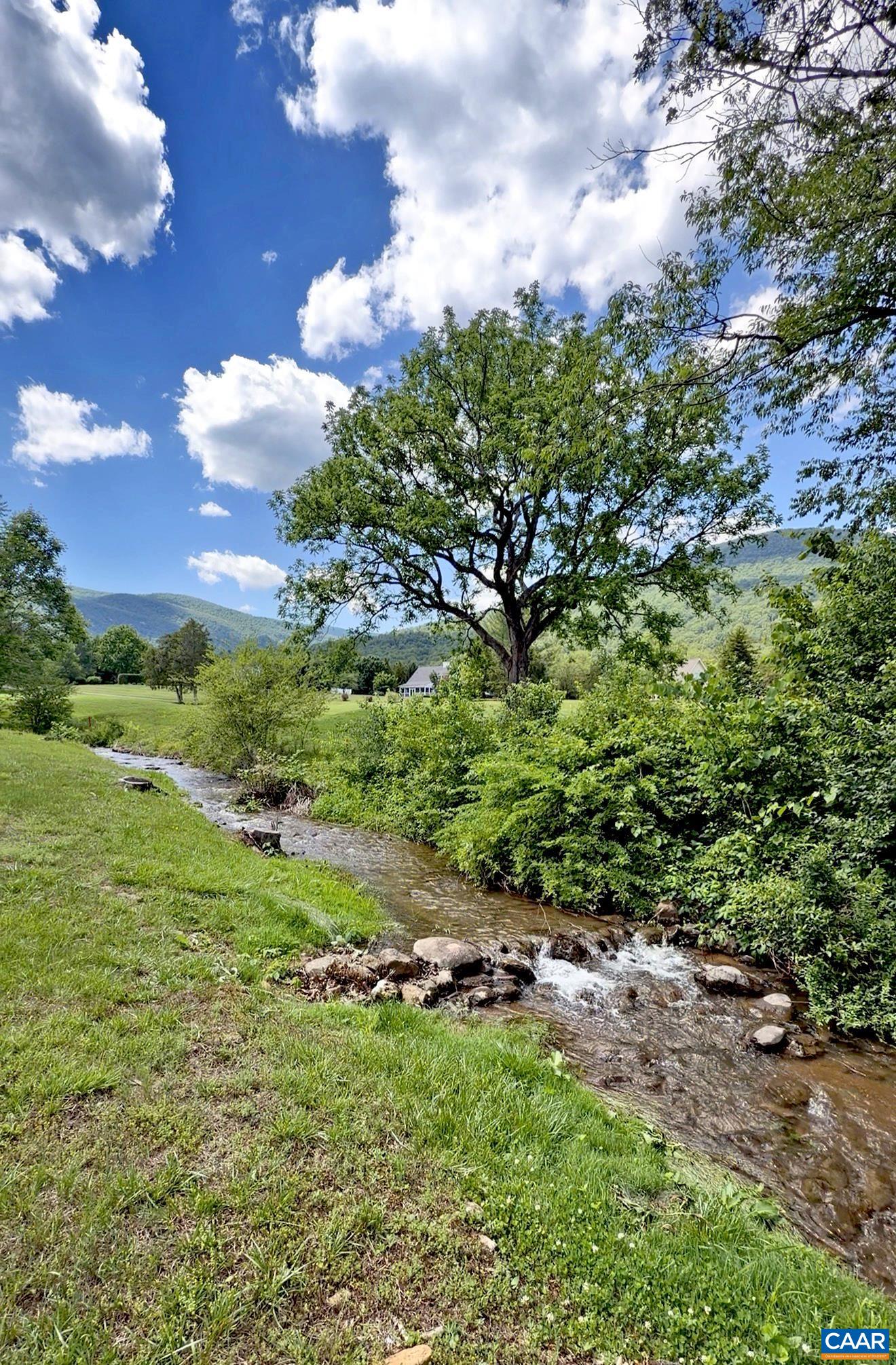 Enjoy peaceful views and the soothing sounds of the flowing creek bordering the backyard