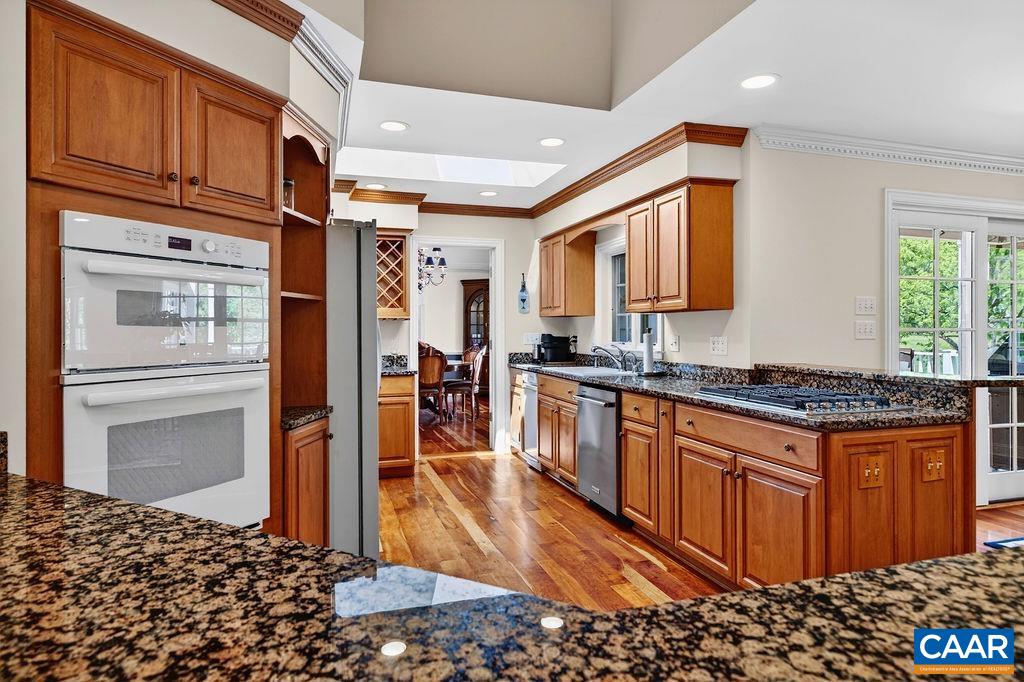 The large kitchen features custom maple cabinets, granite counter tops, gas cook top, wall oven and a second full size oven.