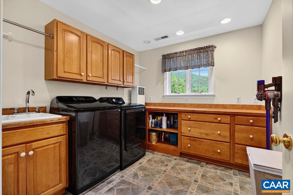 The large laundry room offers a sink, folding ironing board and great laundry folding countertop space.