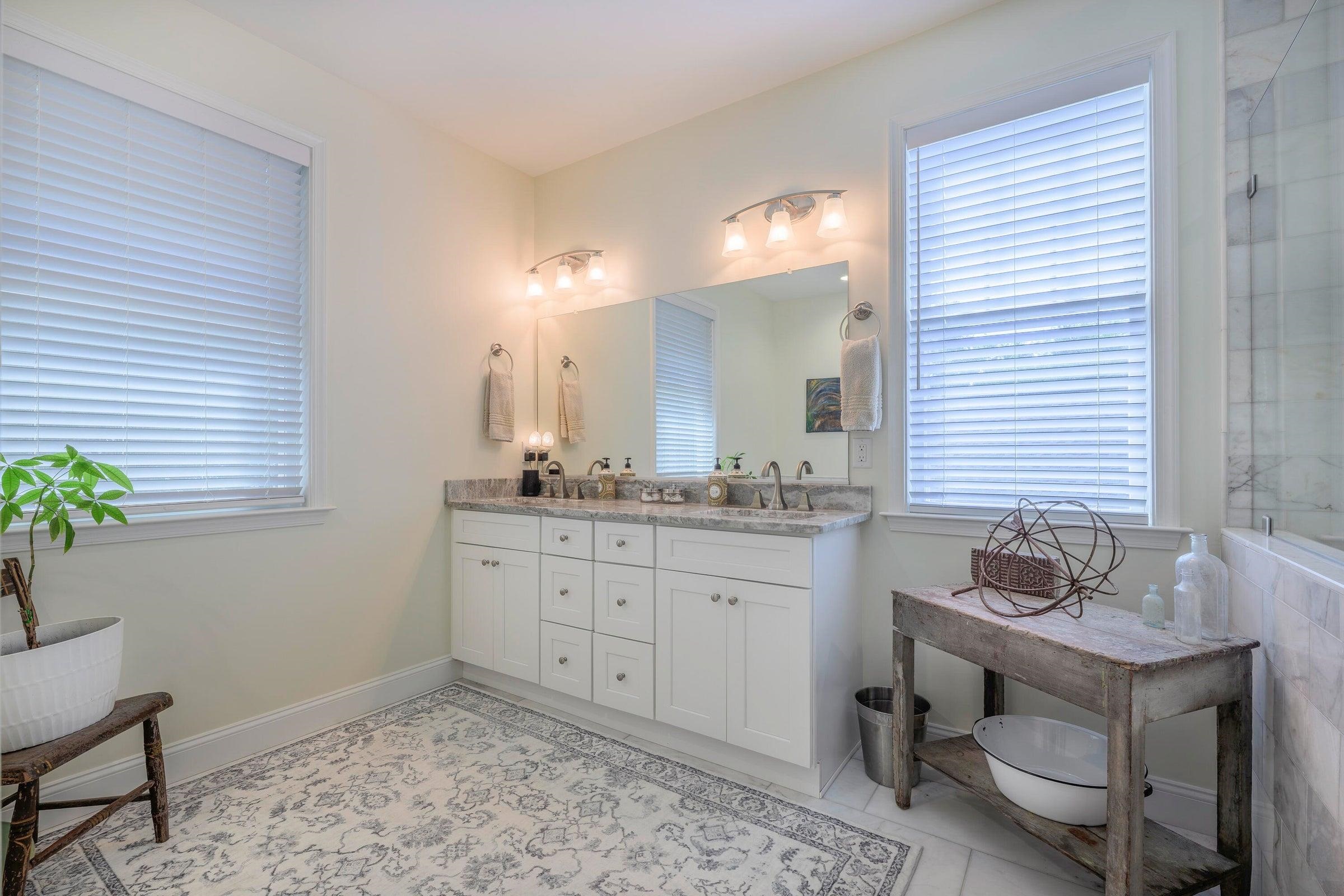 The well-appointed primary bath complete with double vanities, soaking tub, and a frameless glass spa-style shower