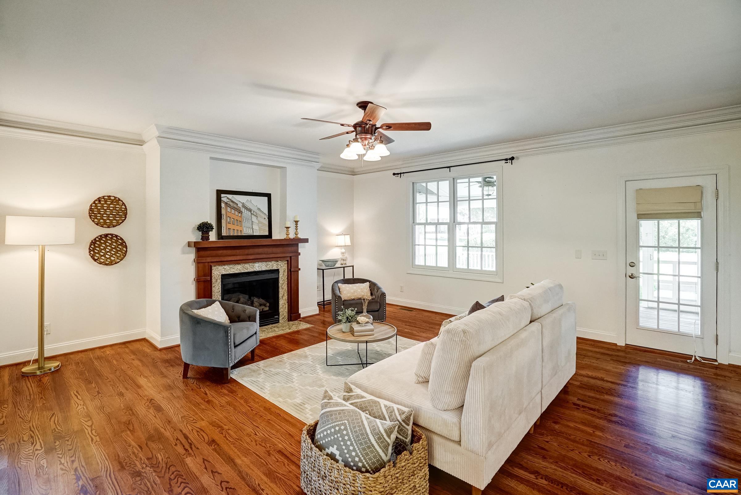 Light filled living room features gas fireplace.