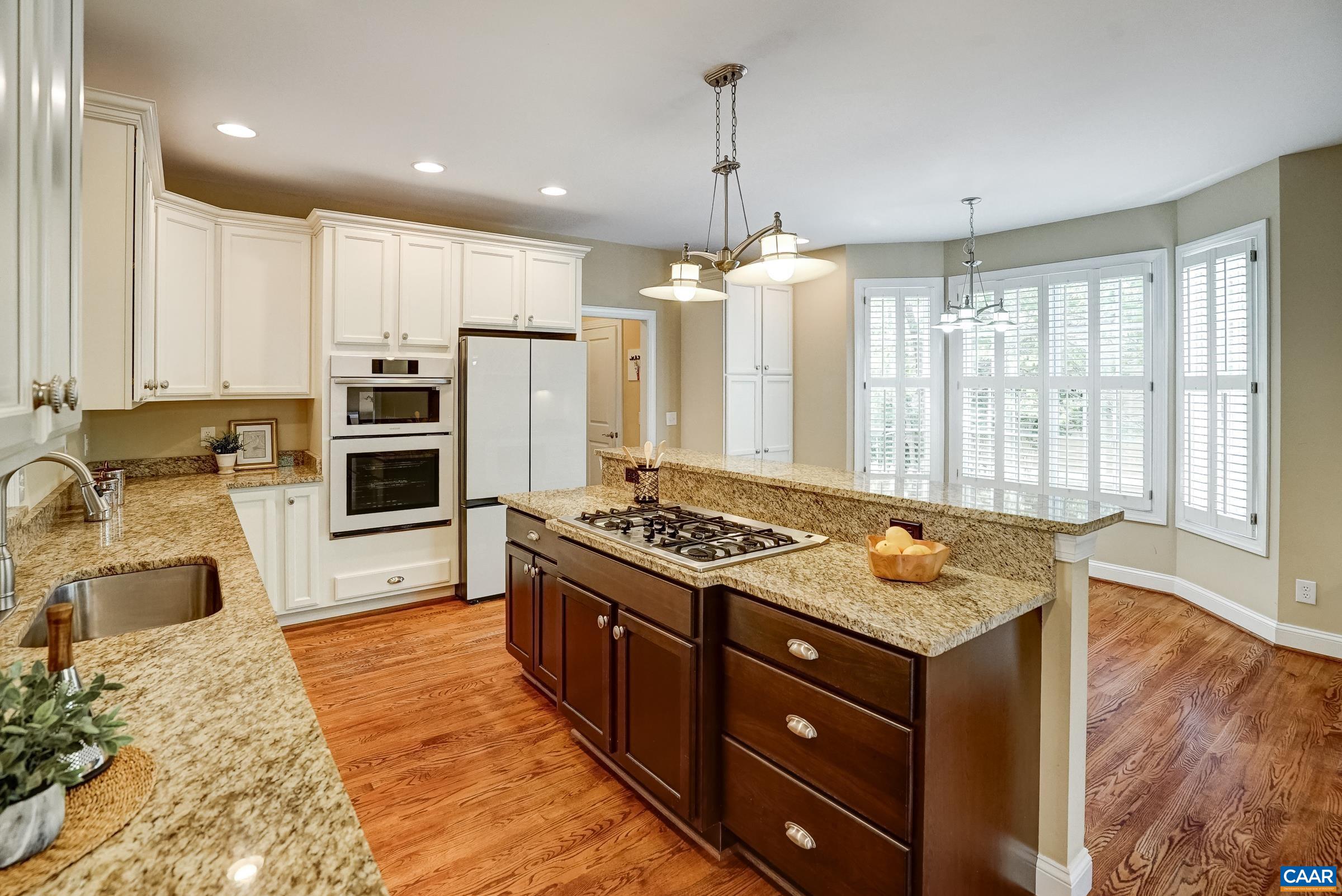 Gourmet kitchen features new Bespoke appliances with white facing including new refrigerator, wall oven and dishwasher.