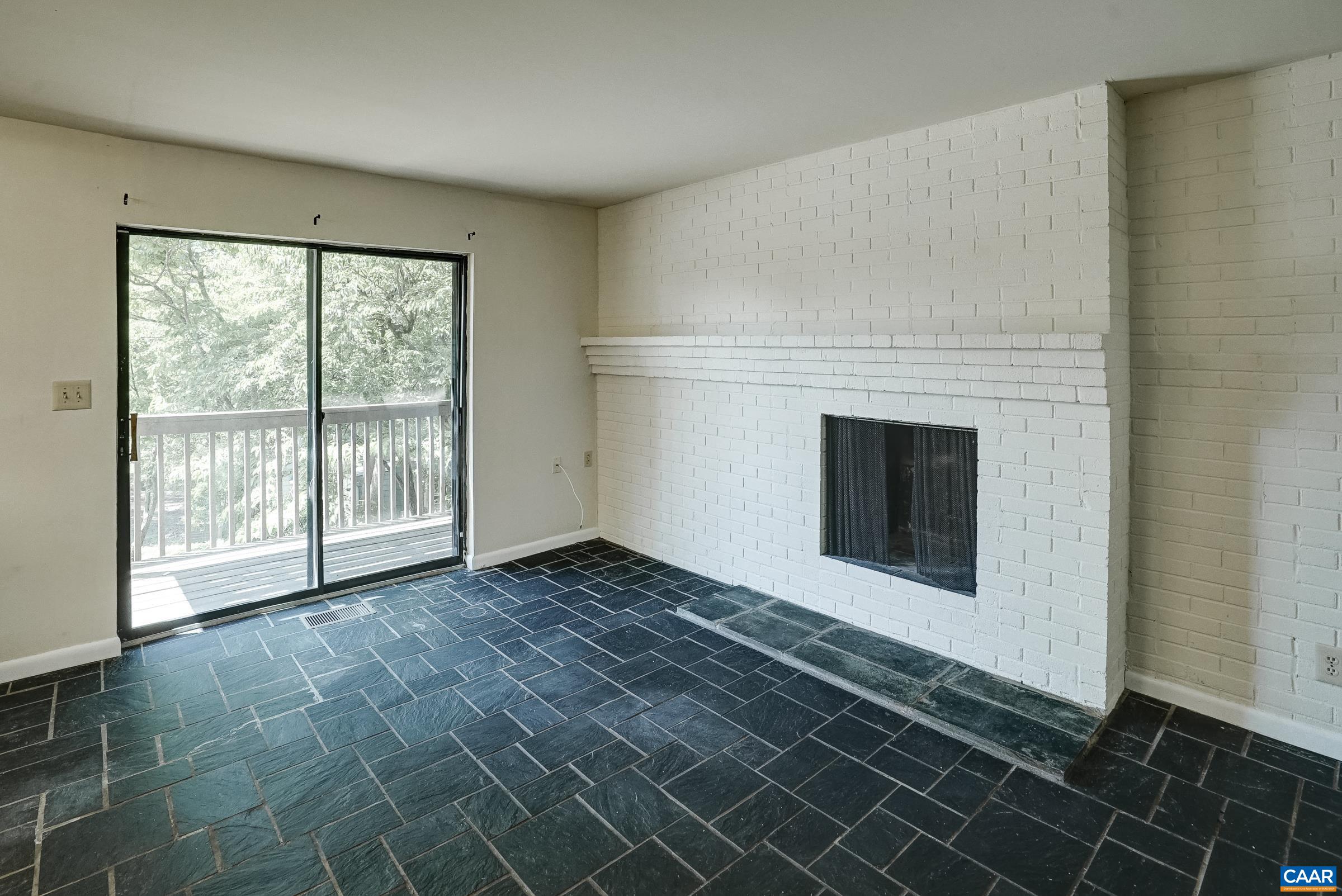 Flexible space adjoining the ktichen features wood-burning fireplace and sliding door access tot he covered deck.