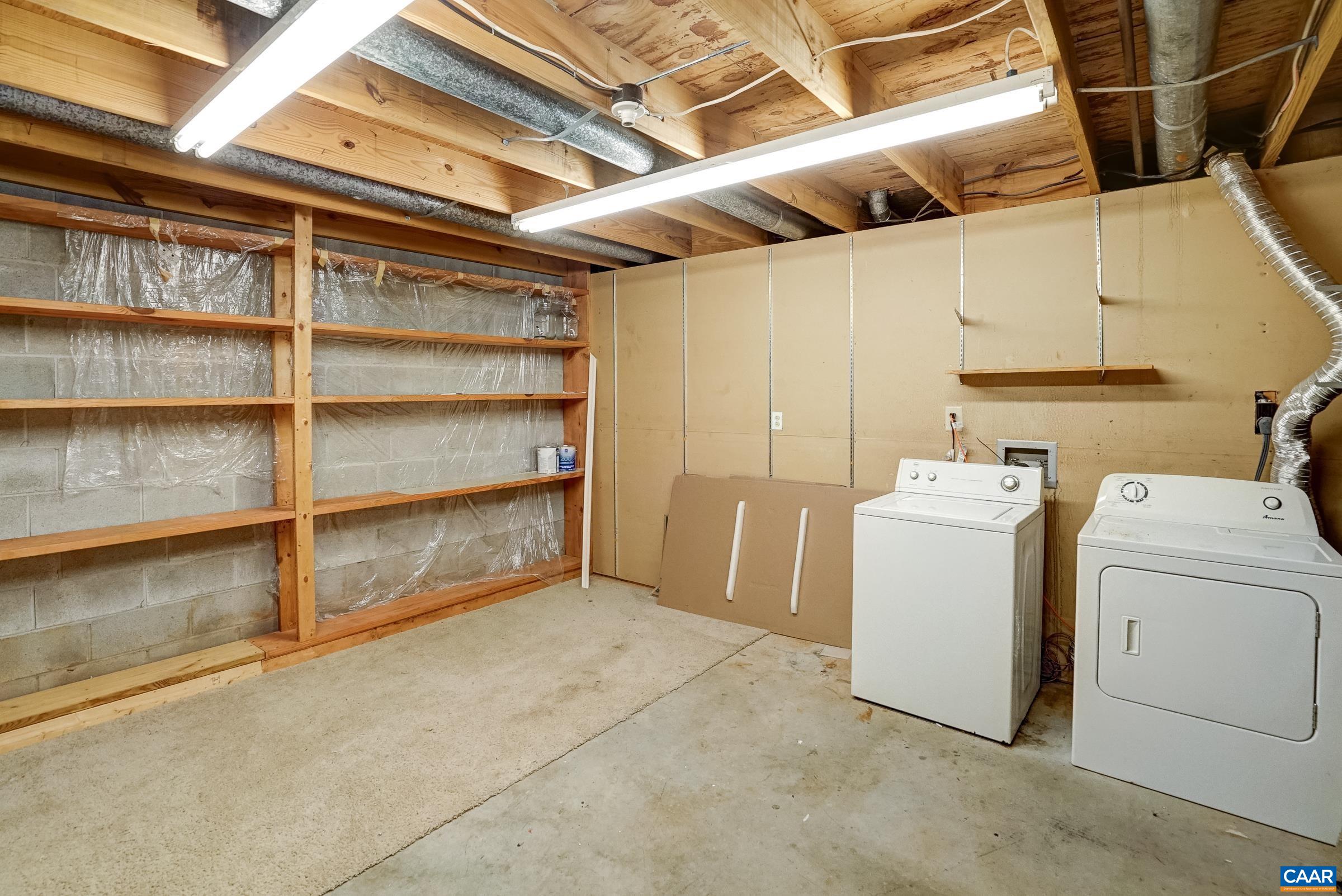 Unfinished area with washer and dryer.