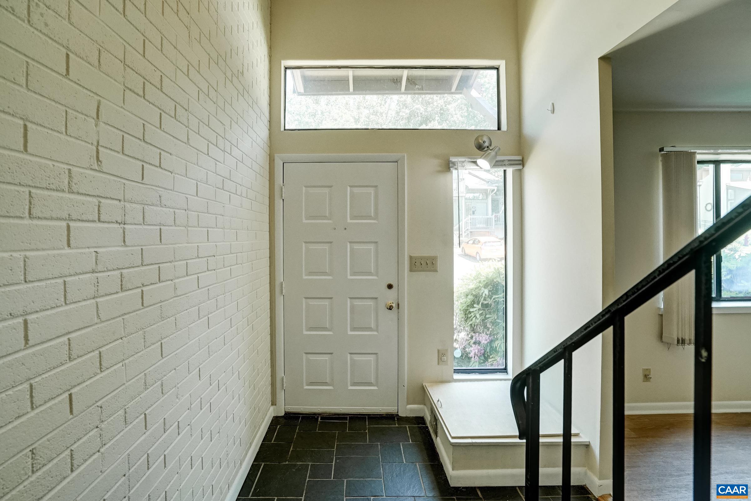 Painted brick wall and ceramic tile floor in the foyer.