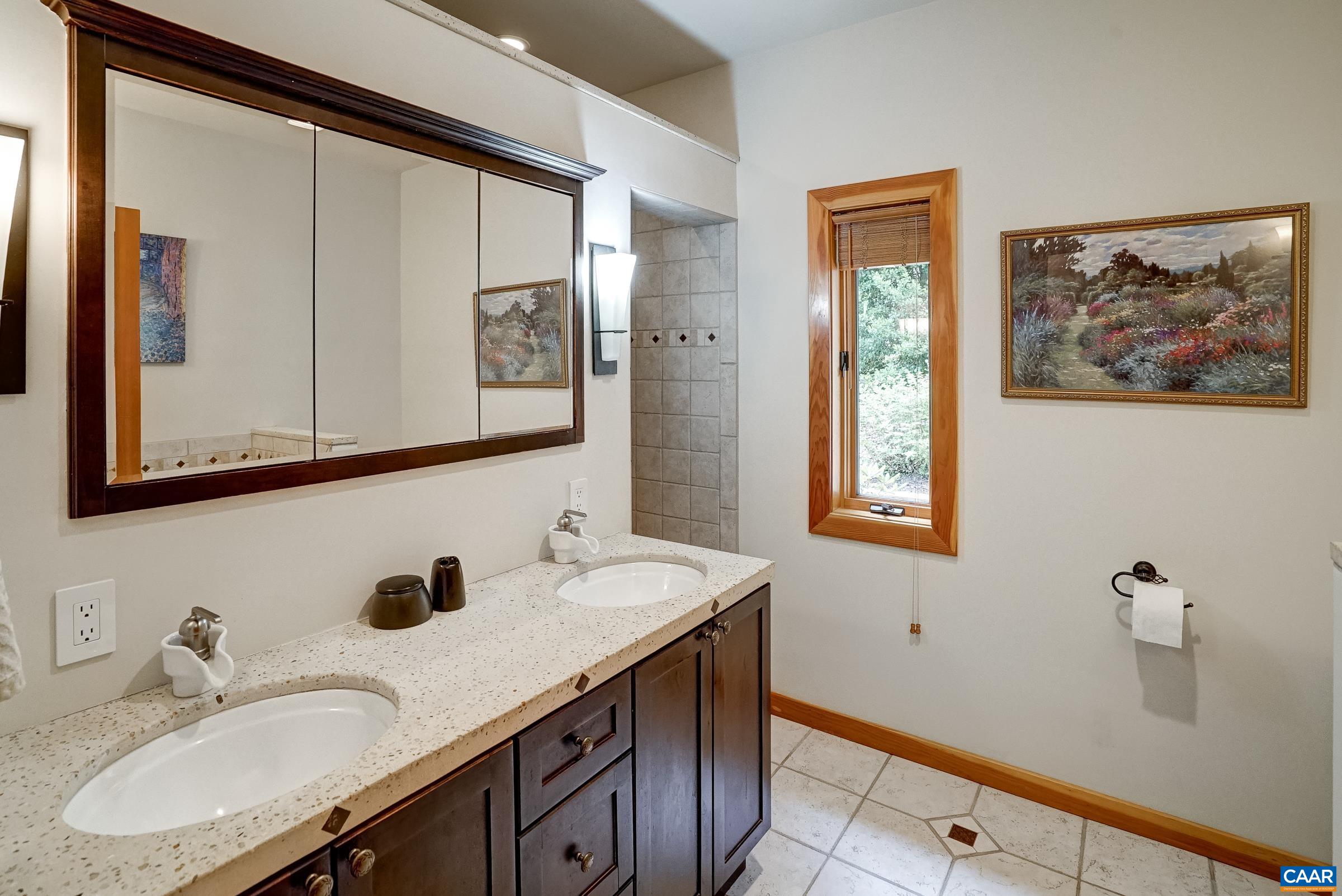 Primary bathroom features double sink vanity and radiant heated floors.