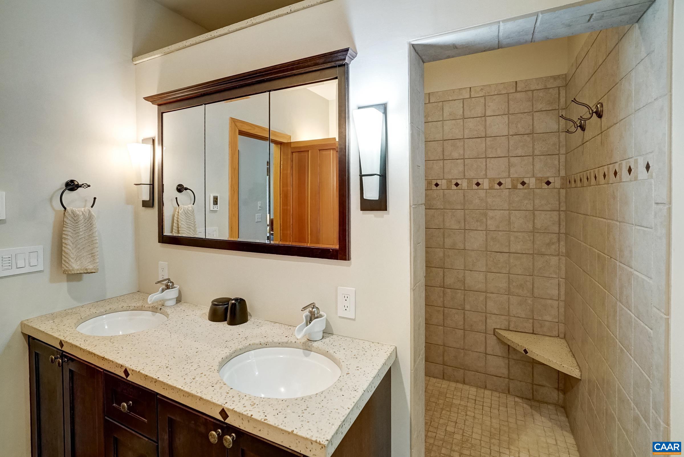 Walk in tile shower with multiple shower heads.