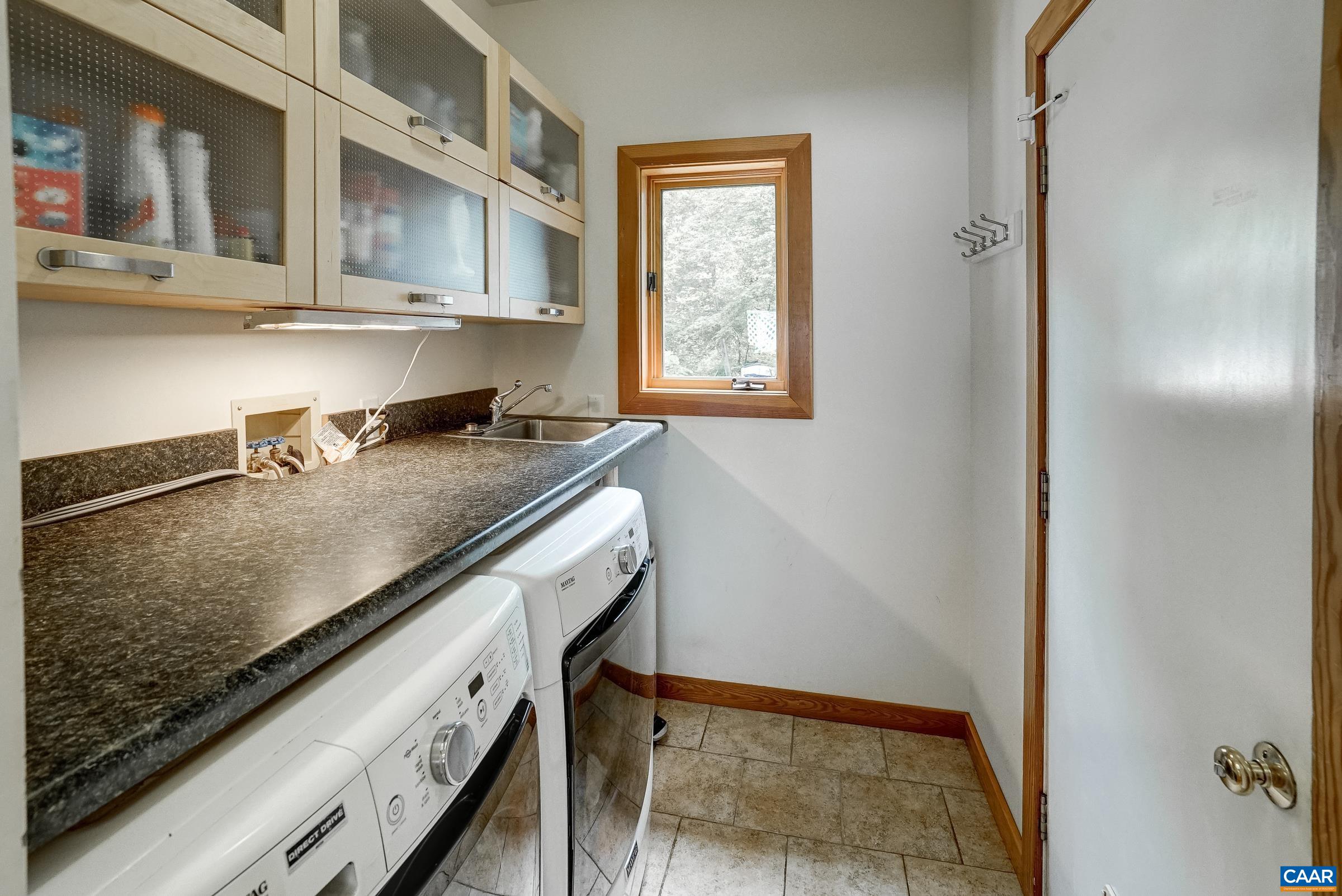 Laundry room with storage and shelving plus utility sink.