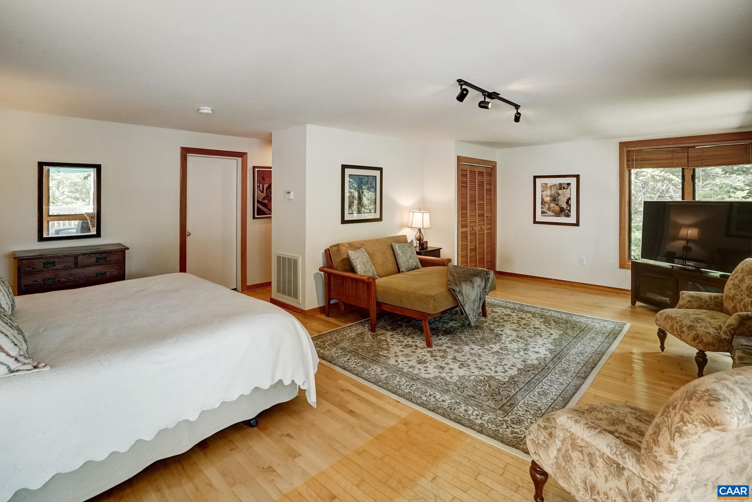 Studio space features sitting area with stone fireplace plus bedroom area and full bathroom.