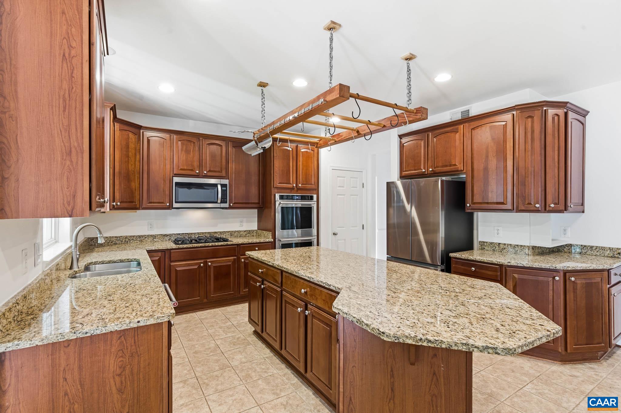 Kitchen with ample storage including pantry and prep space.