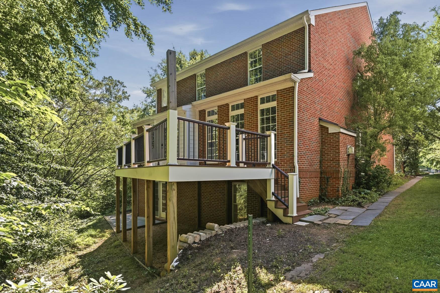 Beloved rear deck, peaceful wooded backdrop, and finished walkout terrace below.