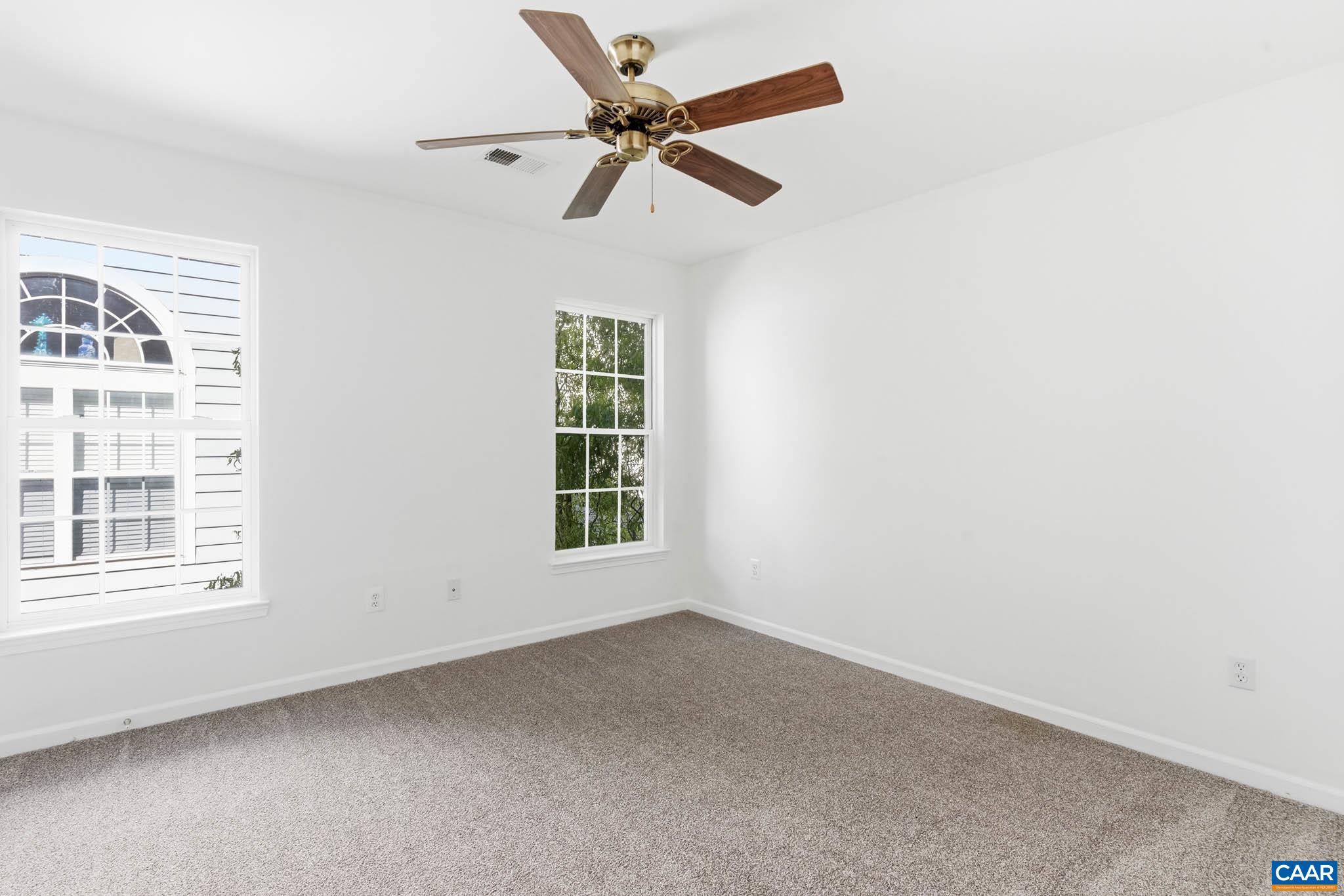 Smaller upstairs bedroom with two windows, suitable for bedroom, nursery, or study space.