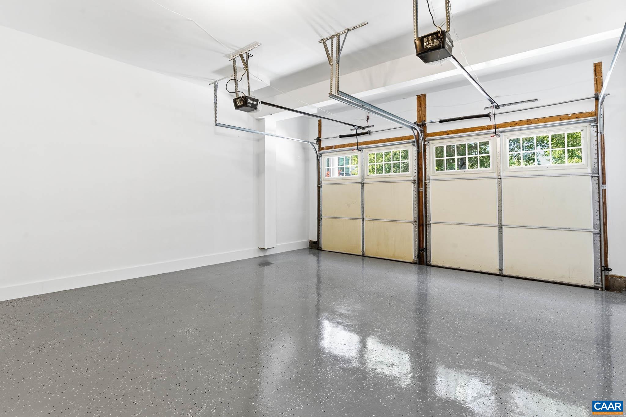 Clean two-car garage with newly finished epoxy floor.