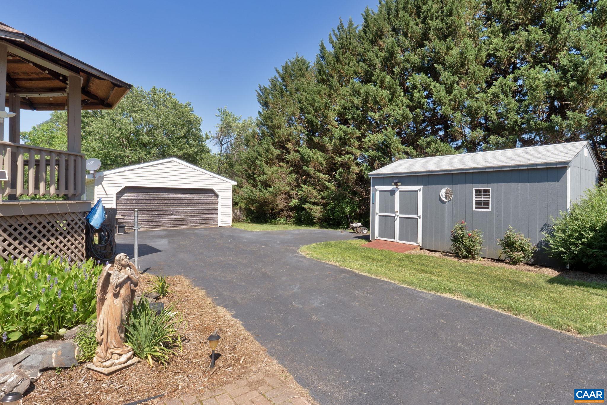 Large two car garage with new roof has room for a shop as well as covered storage behind.