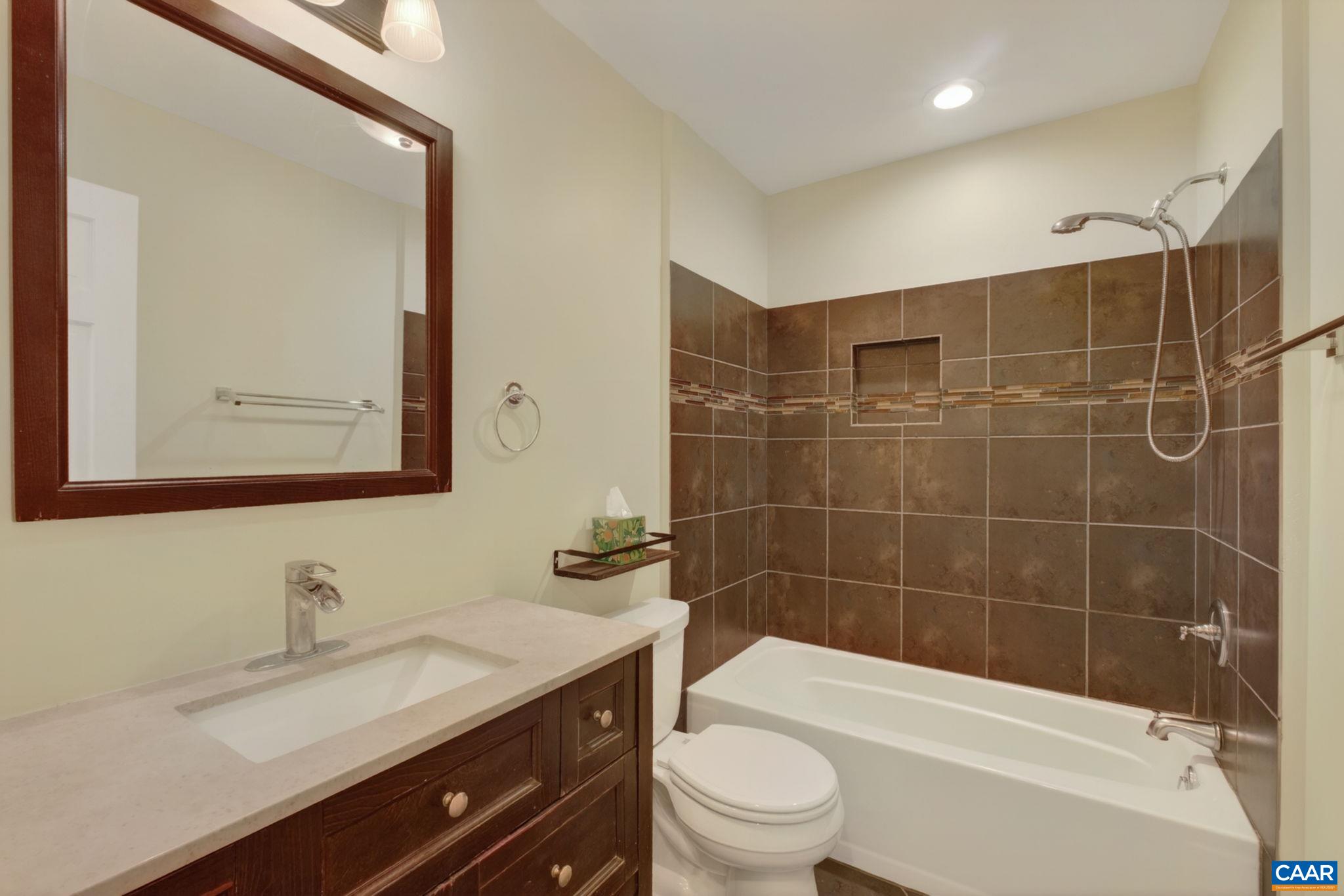 Fully tiled hall bathroom.