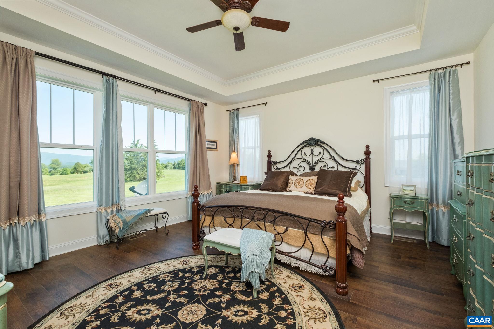 Enter the primary suite from its own hallway. Located on the first floor, with plenty of windows for natural light, a tray ceiling, and a large ensuite bathroom. Enter the primary suite from its own hallway. Located on the first floor, with plenty of windows for natural light, a tray ceiling, and a large ensuite bathroom.