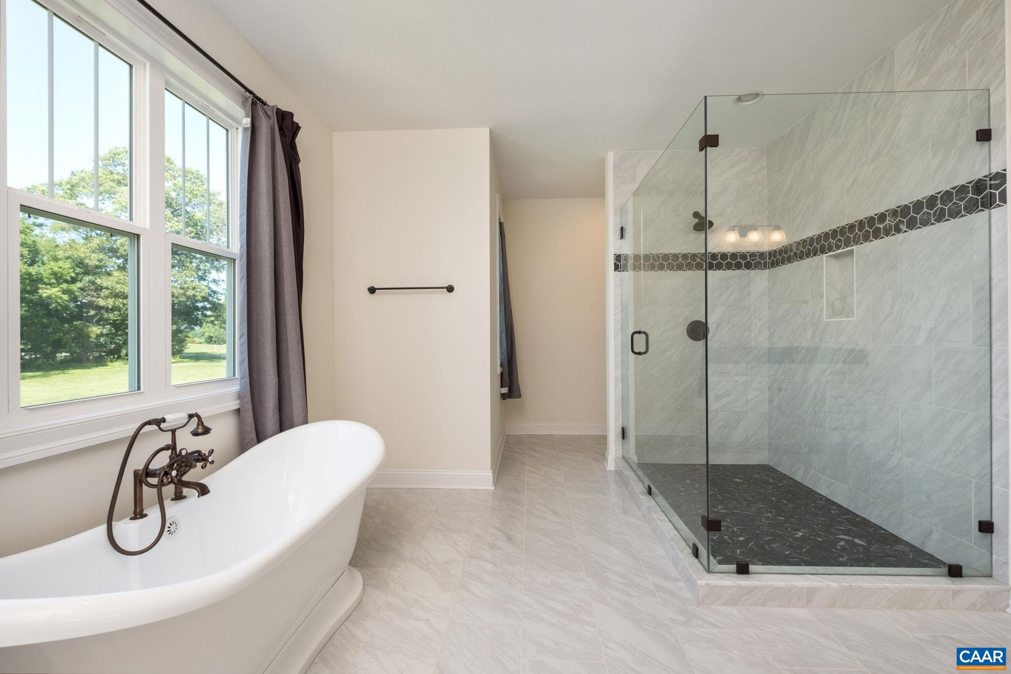 The ensuite bathroom is sizable, with a large granite counter and dual sinks, porcelain tile floor, garden tub, and a large tiled shower. The ensuite bathroom is sizable, with a large granite counter and dual sinks, porcelain tile floor, garden tub, and a large tiled shower.