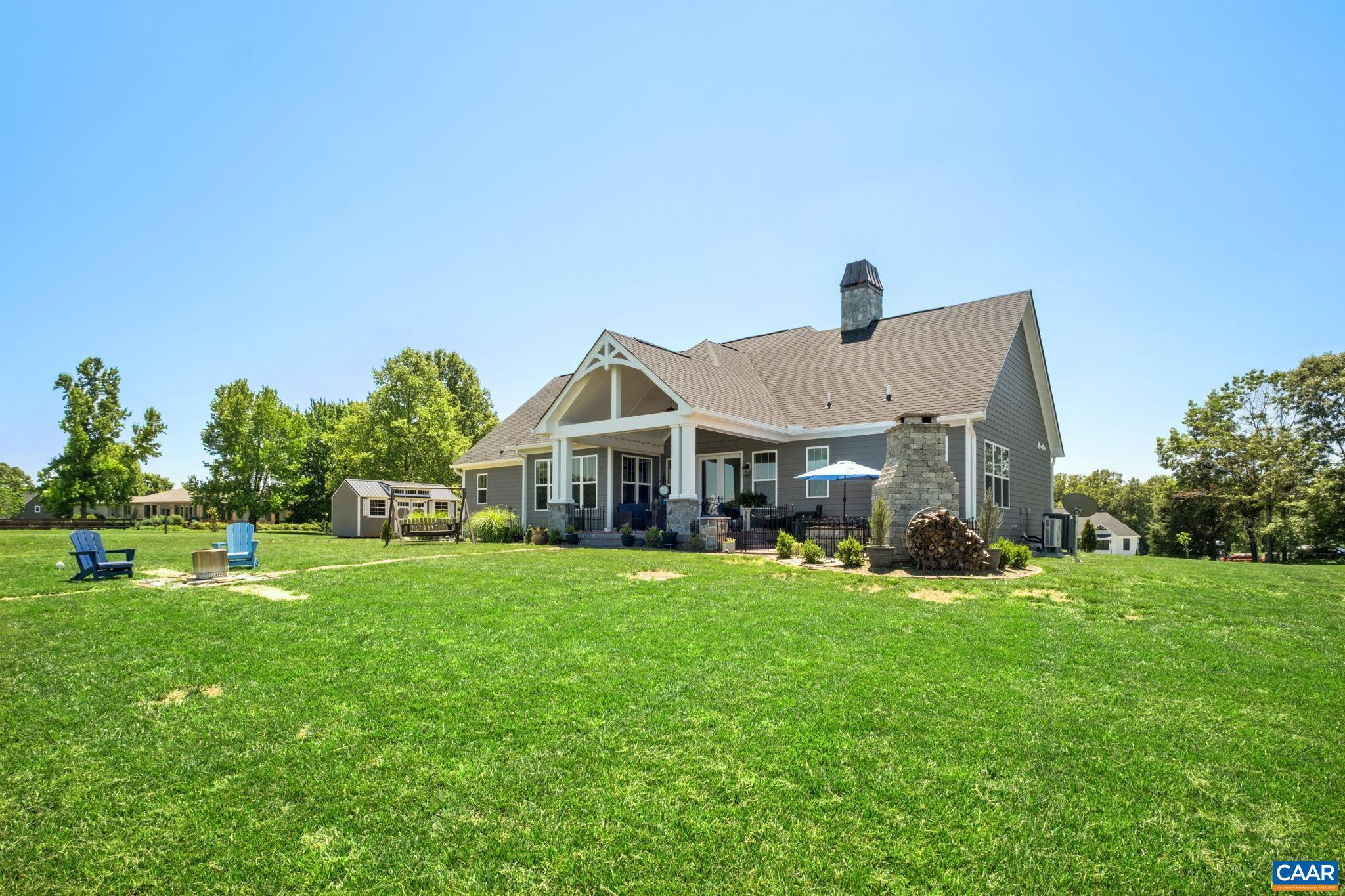 This view is from the backyard looking toward the back of the home/covered porch, and patio. Note the patina chimney top on the house. This view is from the backyard looking toward the back of the home/covered porch, and patio. Note the patina chimney top on the house.