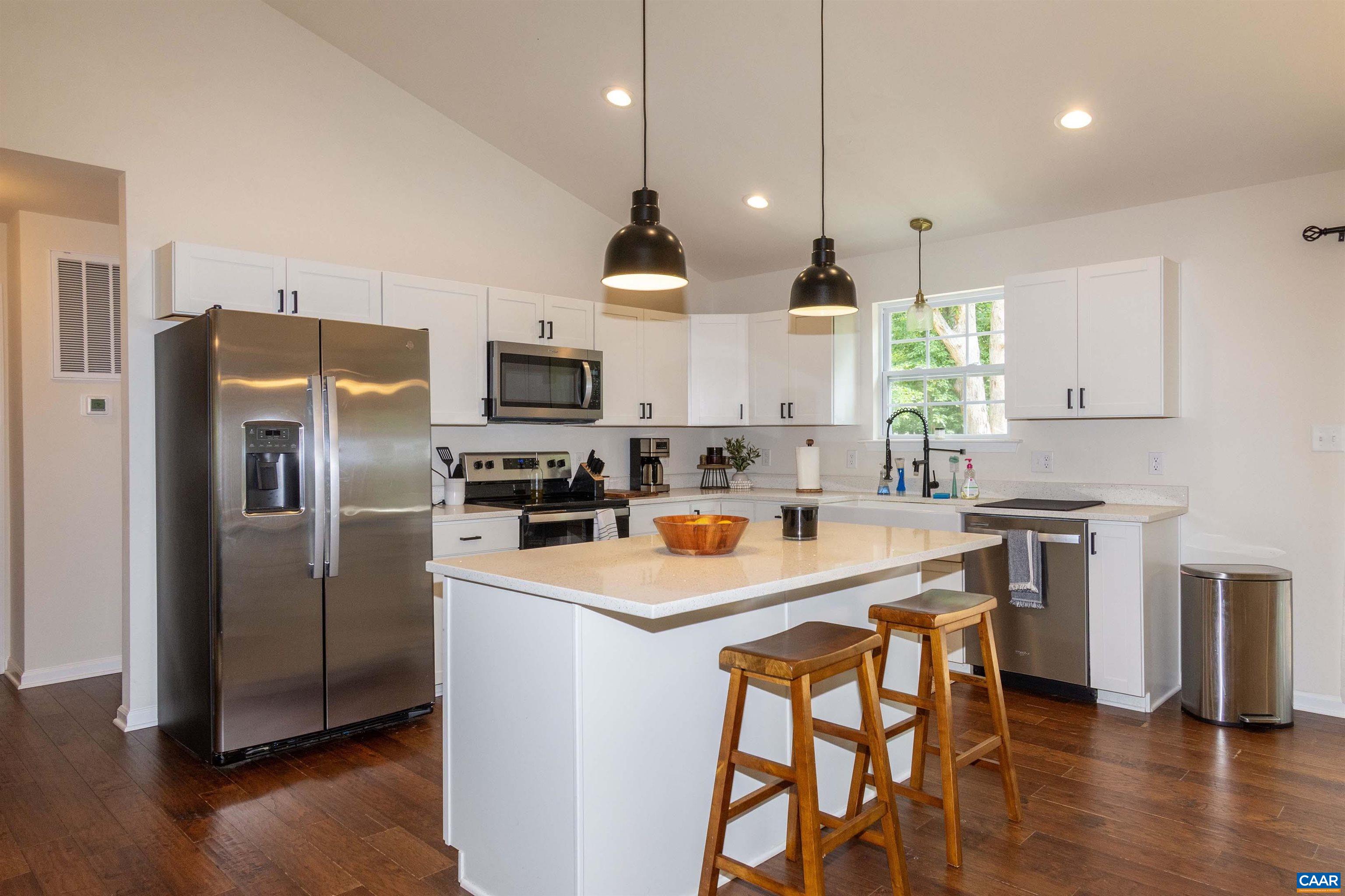 with large island for food prep and overhang for informal dining. Pendant lights and granite counters. with large island for food prep and overhang for informal dining. Pendant lights and granite counters.