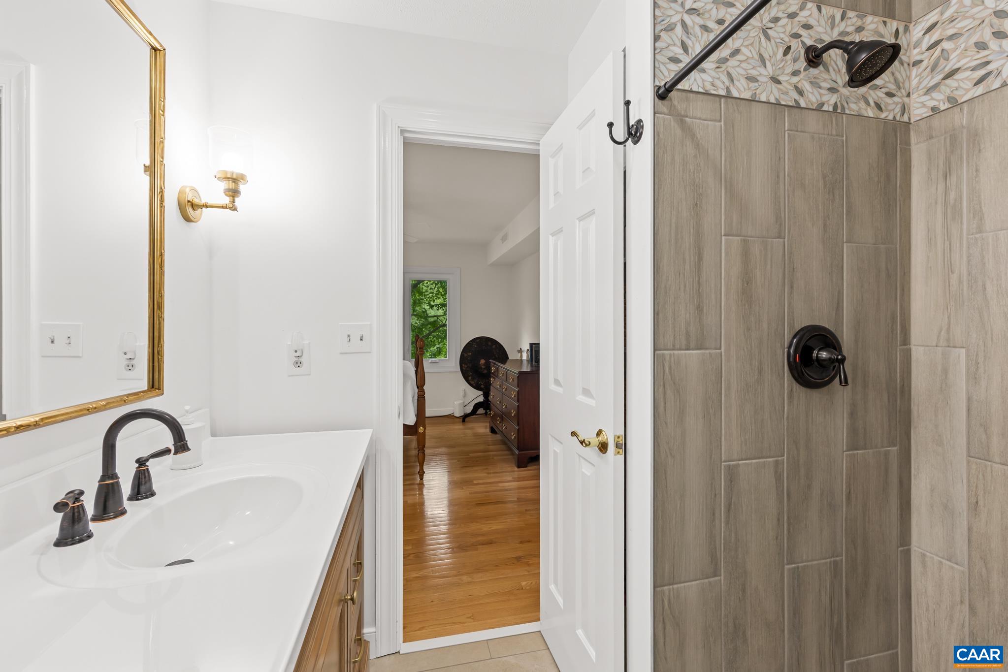 Beautifully remolded primary bath with new fixtures and elegant custom tile. Beautifully remolded primary bath with new fixtures and elegant custom tile.