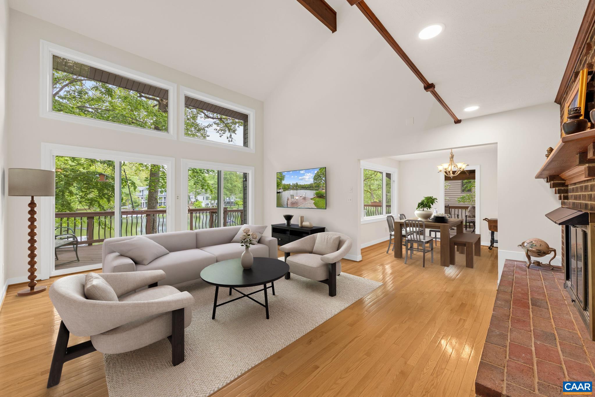 The spacious Livingroom featuring vaulted ceilings, a fireplace and seamless flow to the kitchen with sweeping water views. This is your relaxing destination The spacious Livingroom featuring vaulted ceilings, a fireplace and seamless flow to the kitchen with sweeping water views. This is your relaxing destination