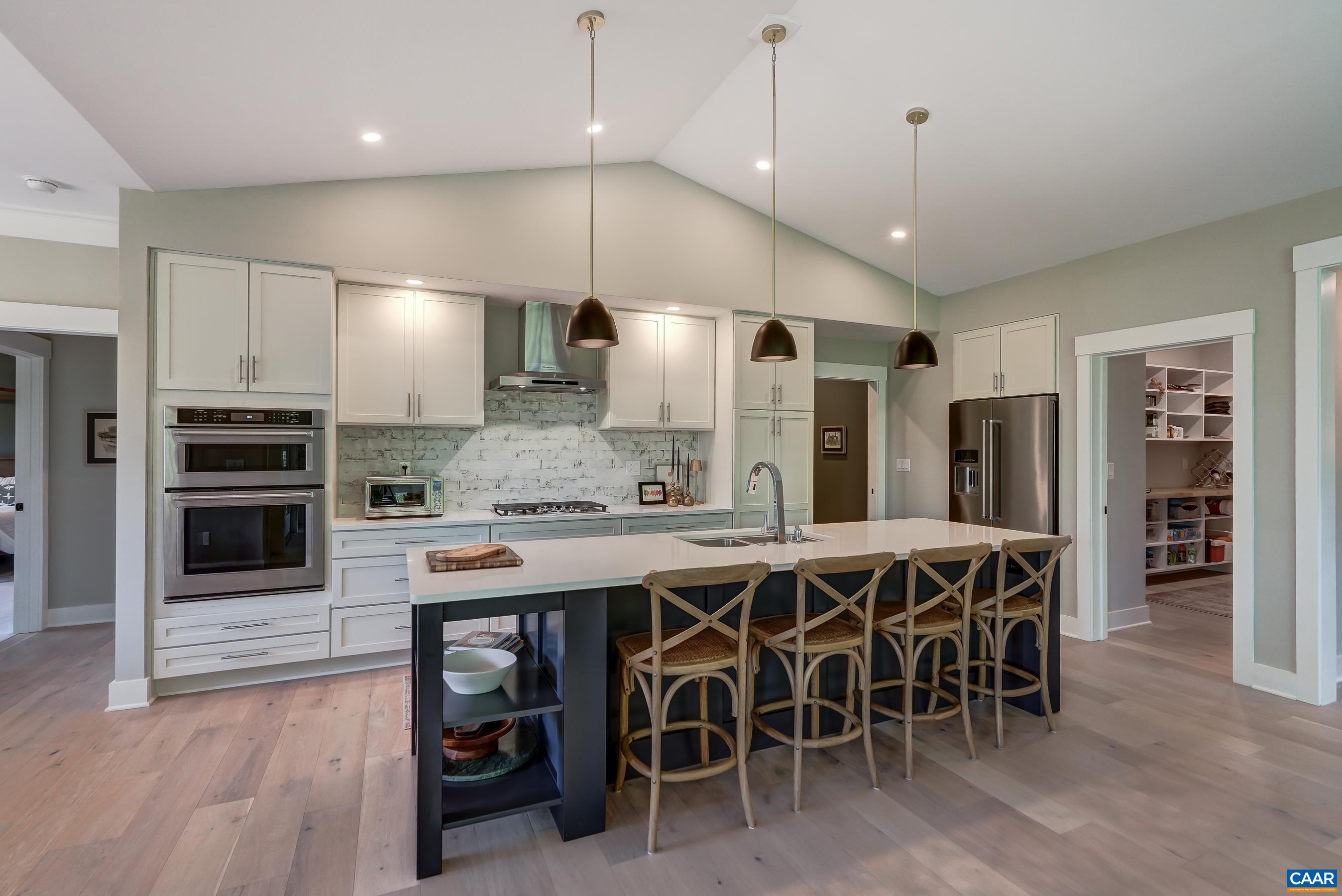 Gourmet kitchen features white cabinets, large island with seating and stainless appliances. Gourmet kitchen features white cabinets, large island with seating and stainless appliances.