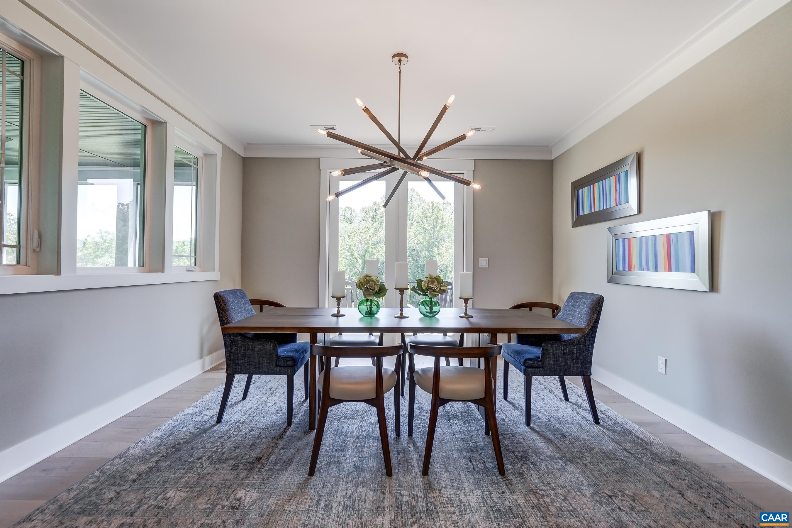Light filled dining area with stunning modern fixture. Light filled dining area with stunning modern fixture.