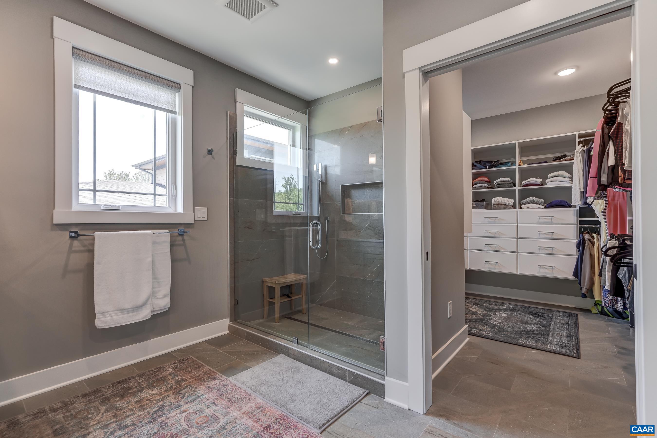 Primary bathroom with beautiful curbless shower, and frameless glass doors. Primary bathroom with beautiful curbless shower, and frameless glass doors.