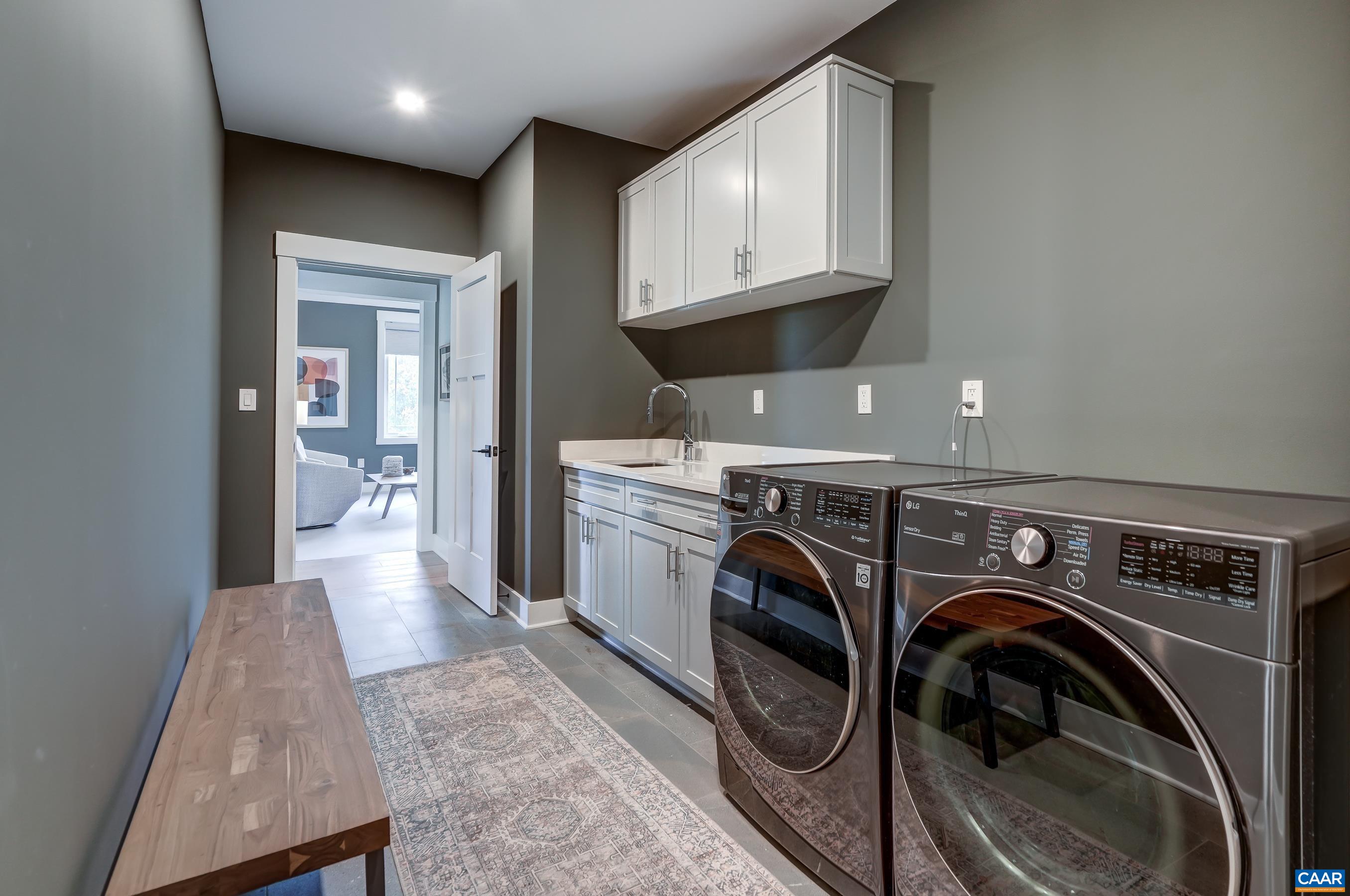 Laundry room with utility sink and storage connects to primary closet. Laundry room with utility sink and storage connects to primary closet.