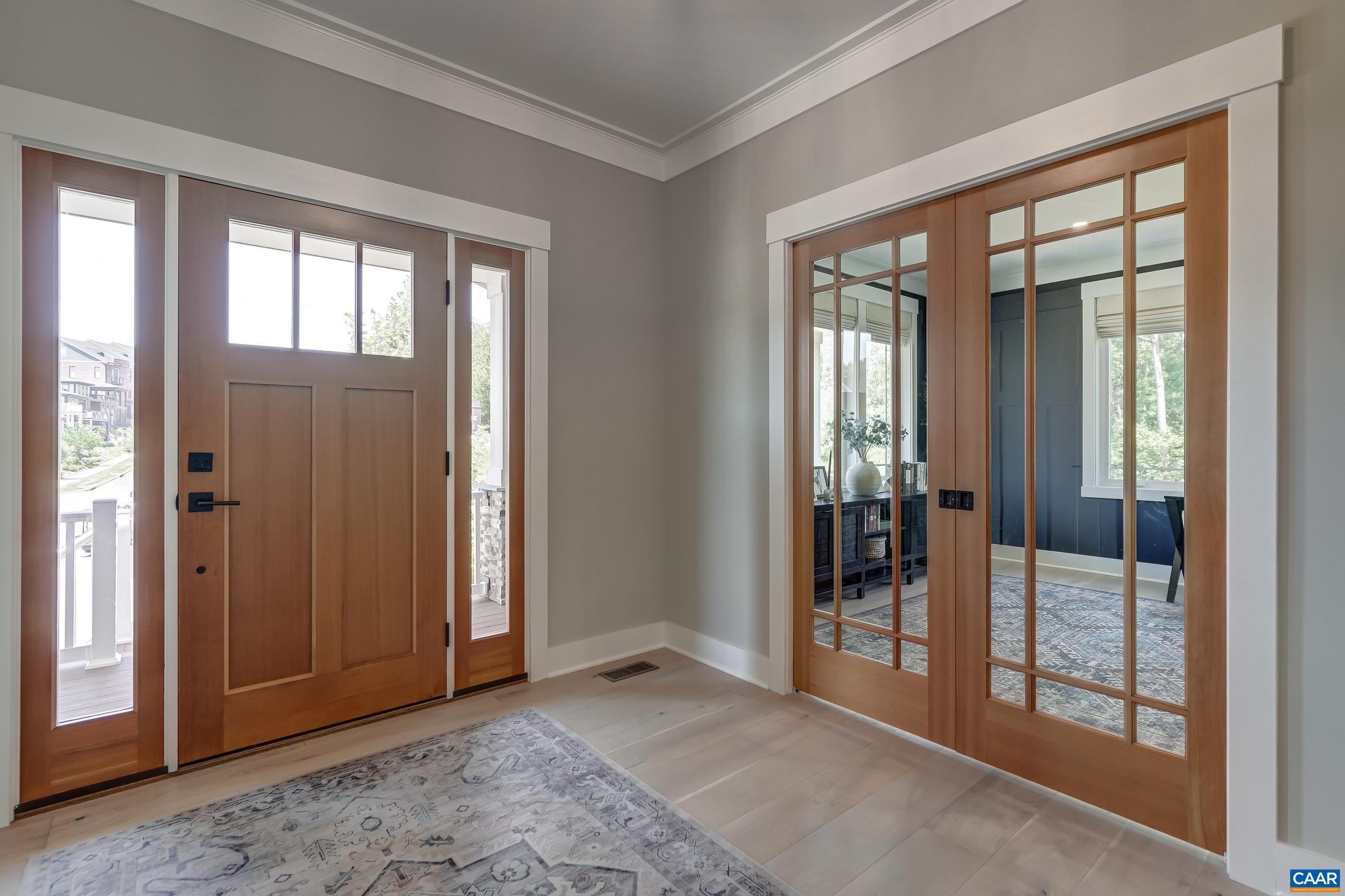 Solid wood front door with sidelights and sliding pocket doors to office. Solid wood front door with sidelights and sliding pocket doors to office.